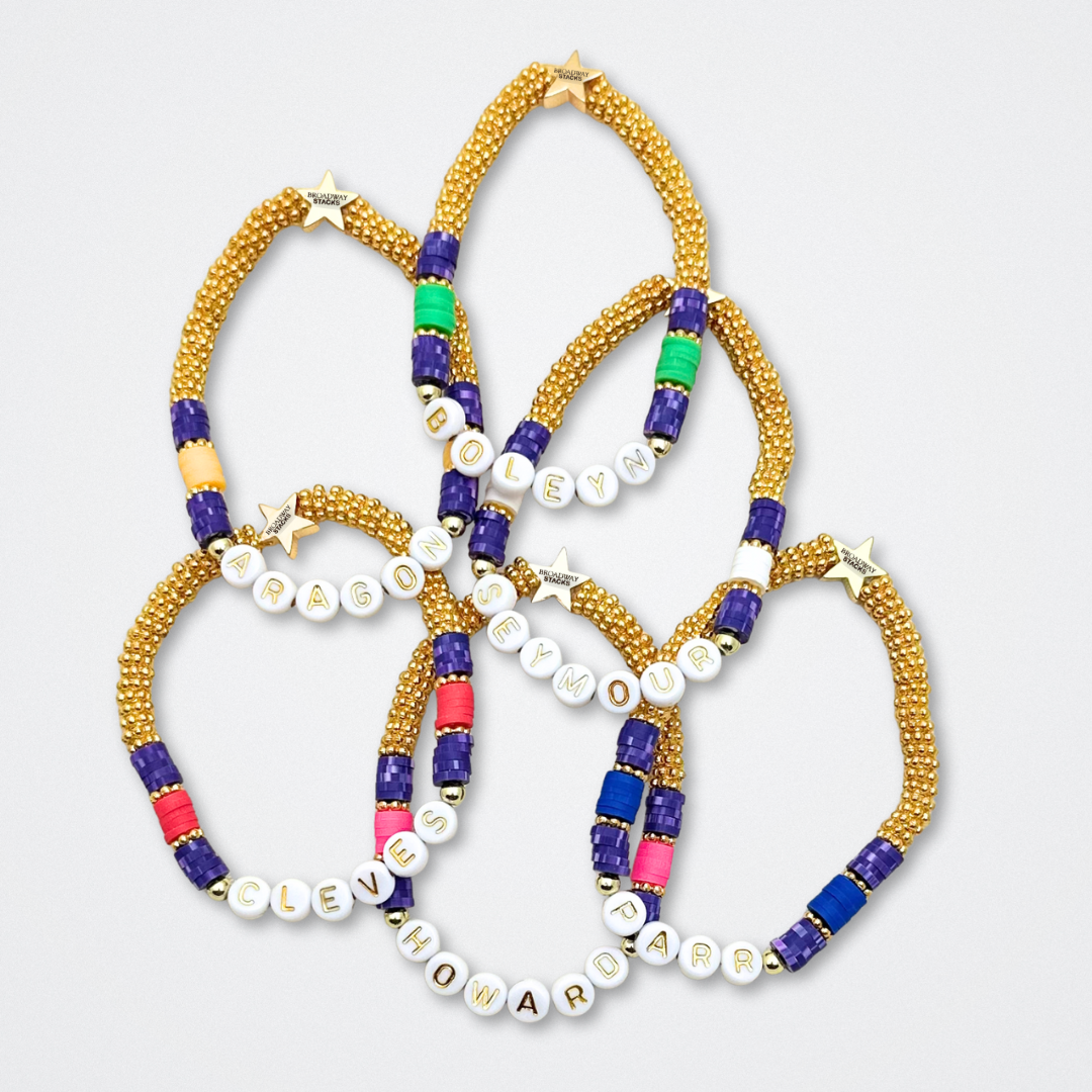 Broadway Stacks QUEEN collection. Stretch bracelets included in Stack. Gold, yellow, green, white, red, pink and blue colored beads. Letter beads that spell each queen. Also Herstory collection. Broadway Stacks gold star logo bead to remind you that You Shine. SIX the Musical fans.
