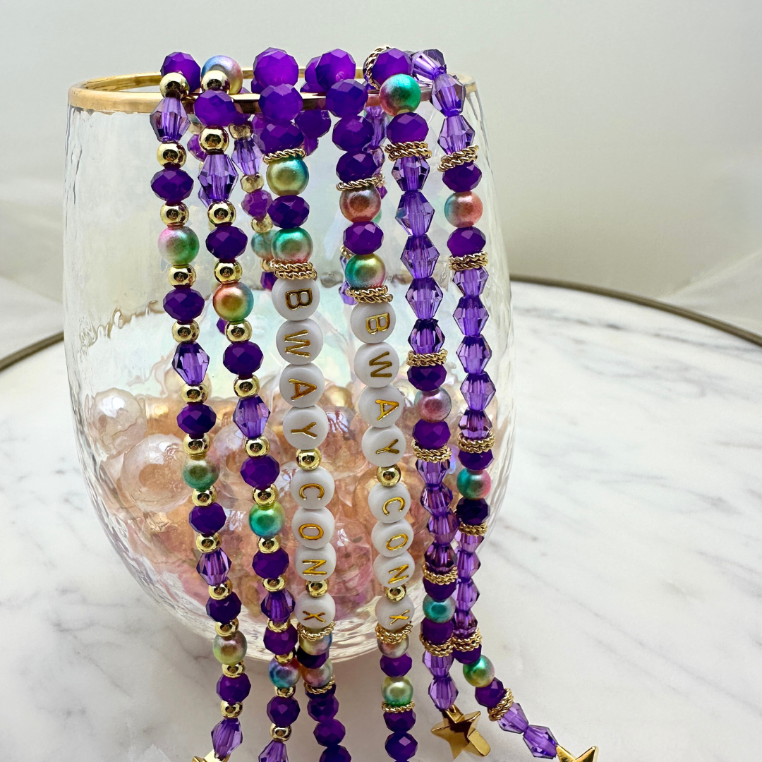 Broadway Stacks BroadwayCon X 2025 Special Edition bracelet. Purple, gold and iridescent colored beads. Letter beads that spell Bway Con X.