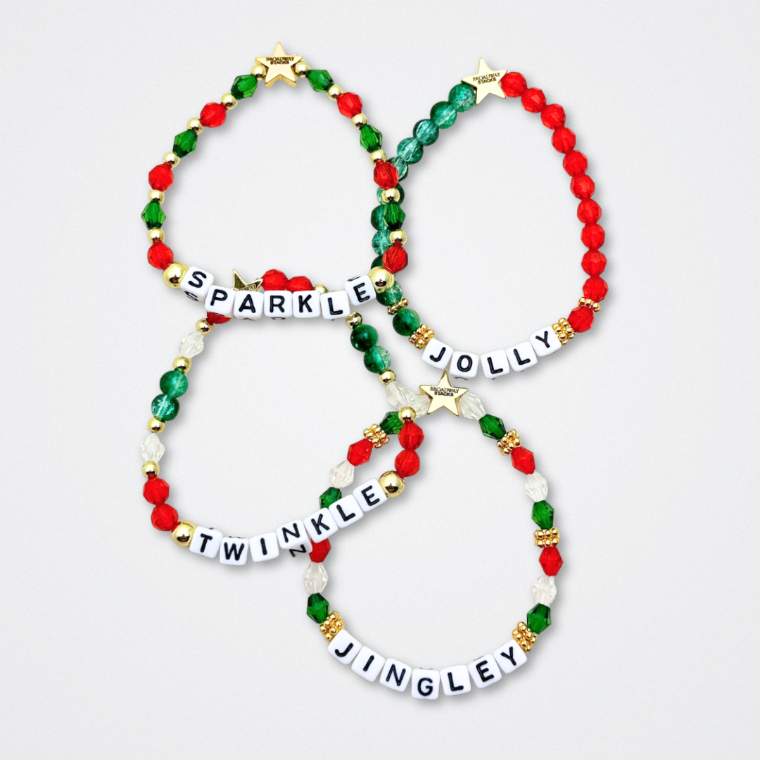 Broadway Stacks CHRISTMAS ELF Collection. Coordinating bead bracelets included in Stack. Red, green, white and gold colored beads. Letter beads that spell quotes. Gold star logo bead to remind you that you shine. Elf the Musical and Christmas holiday fans.