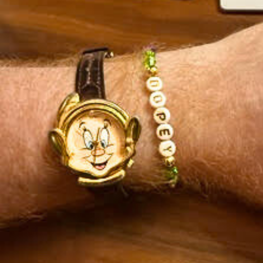Broadway Stacks Special Edition bracelet. Green, yellow, purple and gold beads. Letter beads that spell Dopey. A portion of the proceeds go to Gilana's Fund. Gold star logo bead to remind you that you shine.