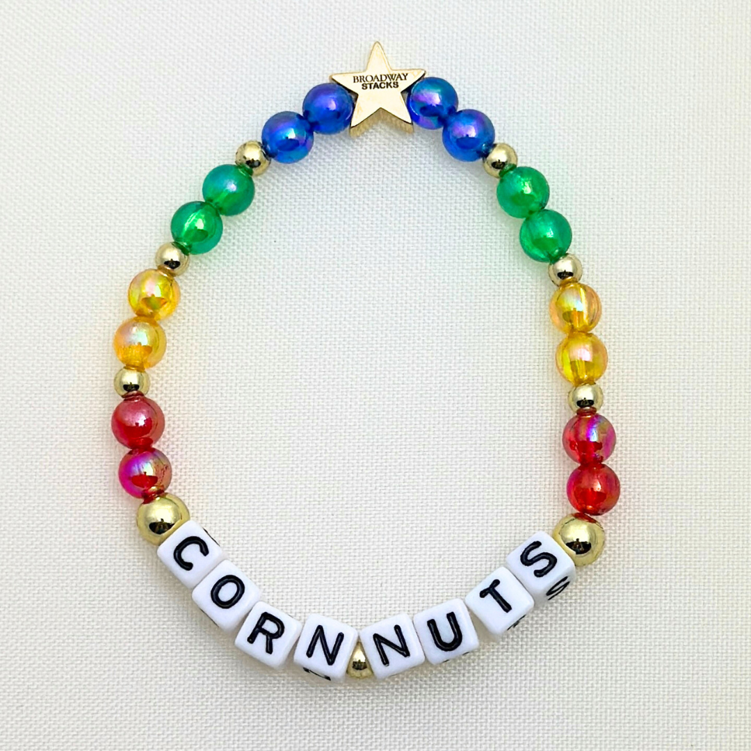 Broadway Stacks CORN NUTS Collection. 5 stretch bracelets included in Stack. Red, yellow, green, blue, black and gold colored beads. Letter beads that spell quotes. Gold star logo bead to remind you that you shine. Heathers the Musical fans.