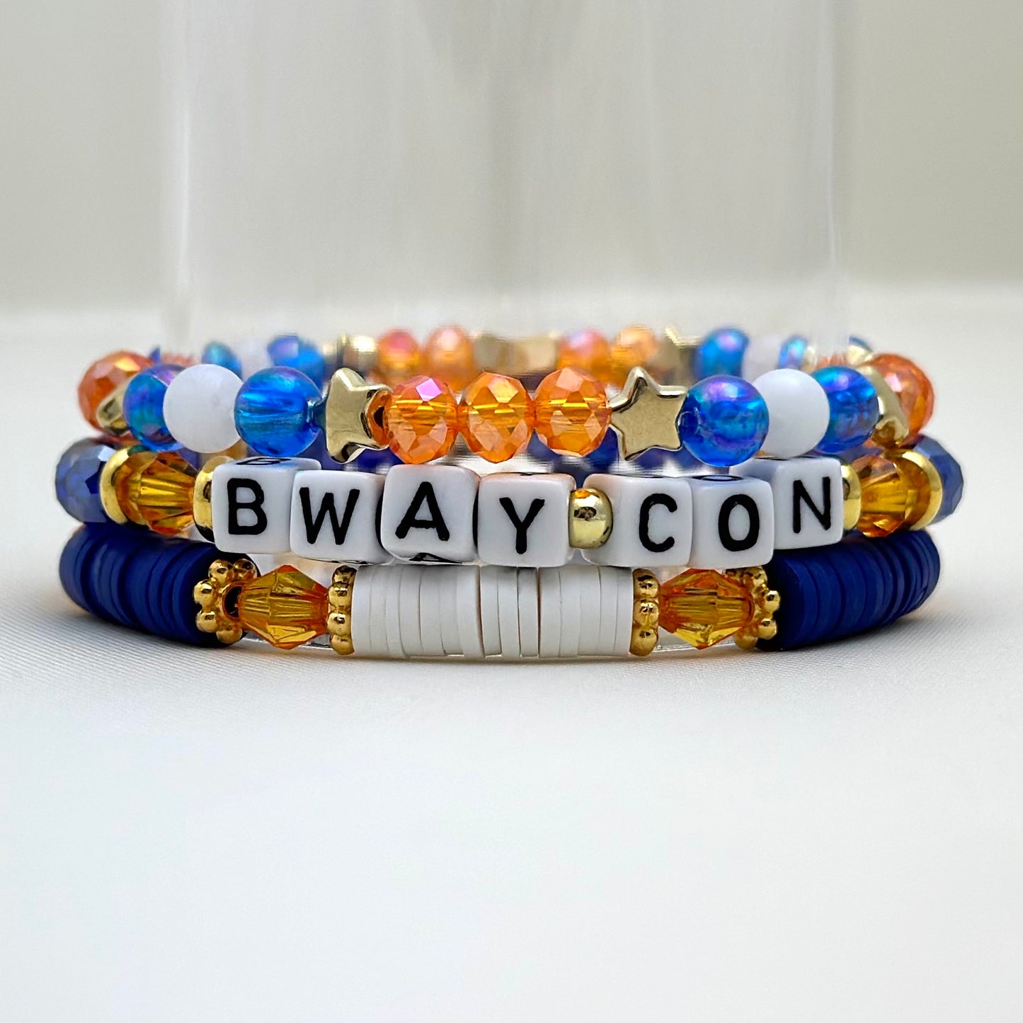 Broadway Stacks BroadwayCon 2024 Special Edition bracelet. 1 stretch bracelet. Blue, orange, white and gold colored beads. Letter beads that spell Bway Con.