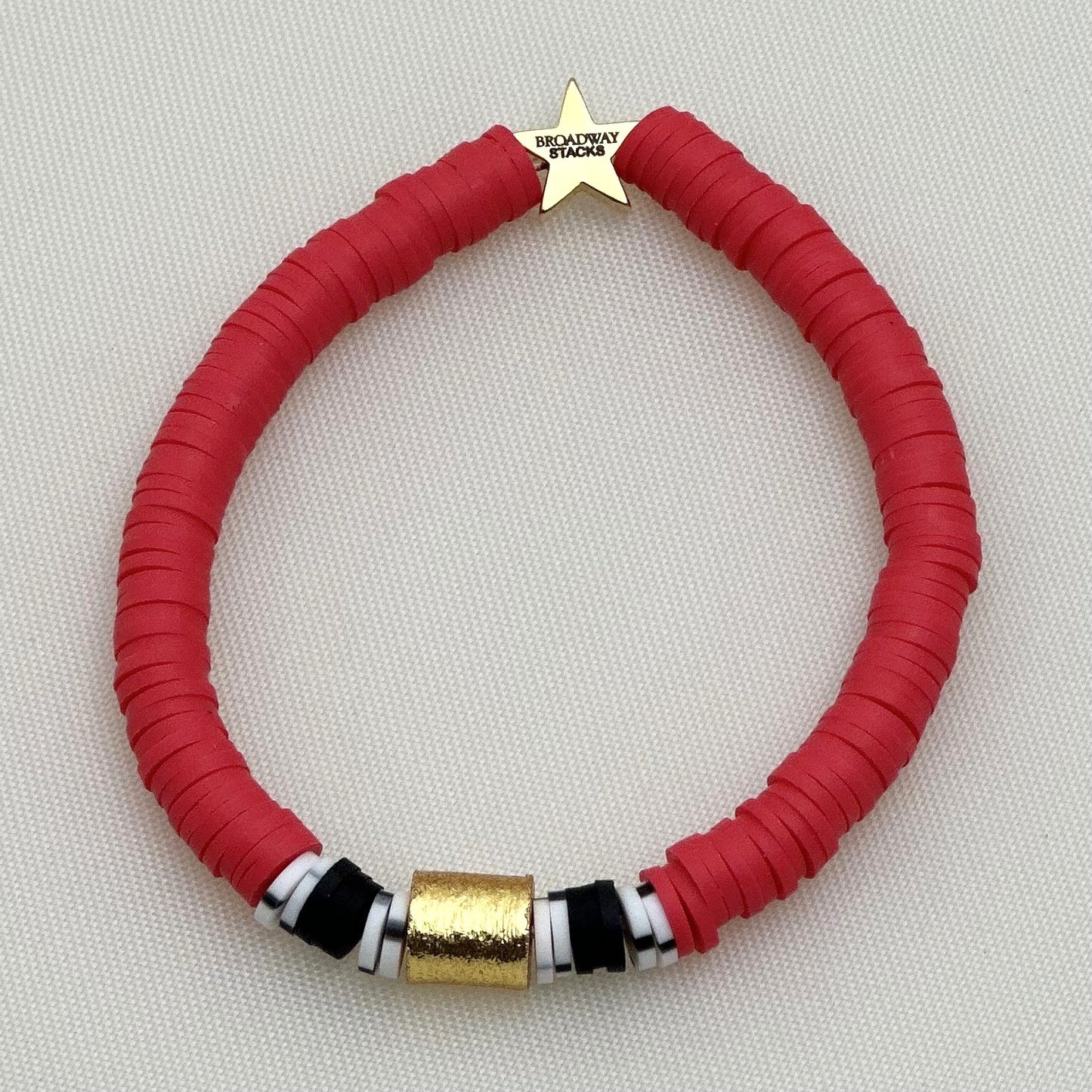 Broadway Stacks MASK collection. 3 stretch bracelets included in Stack. Red, white, gold and black colored beads. Letter beads that spell show quotes. Broadway Stacks gold star logo bead on back.