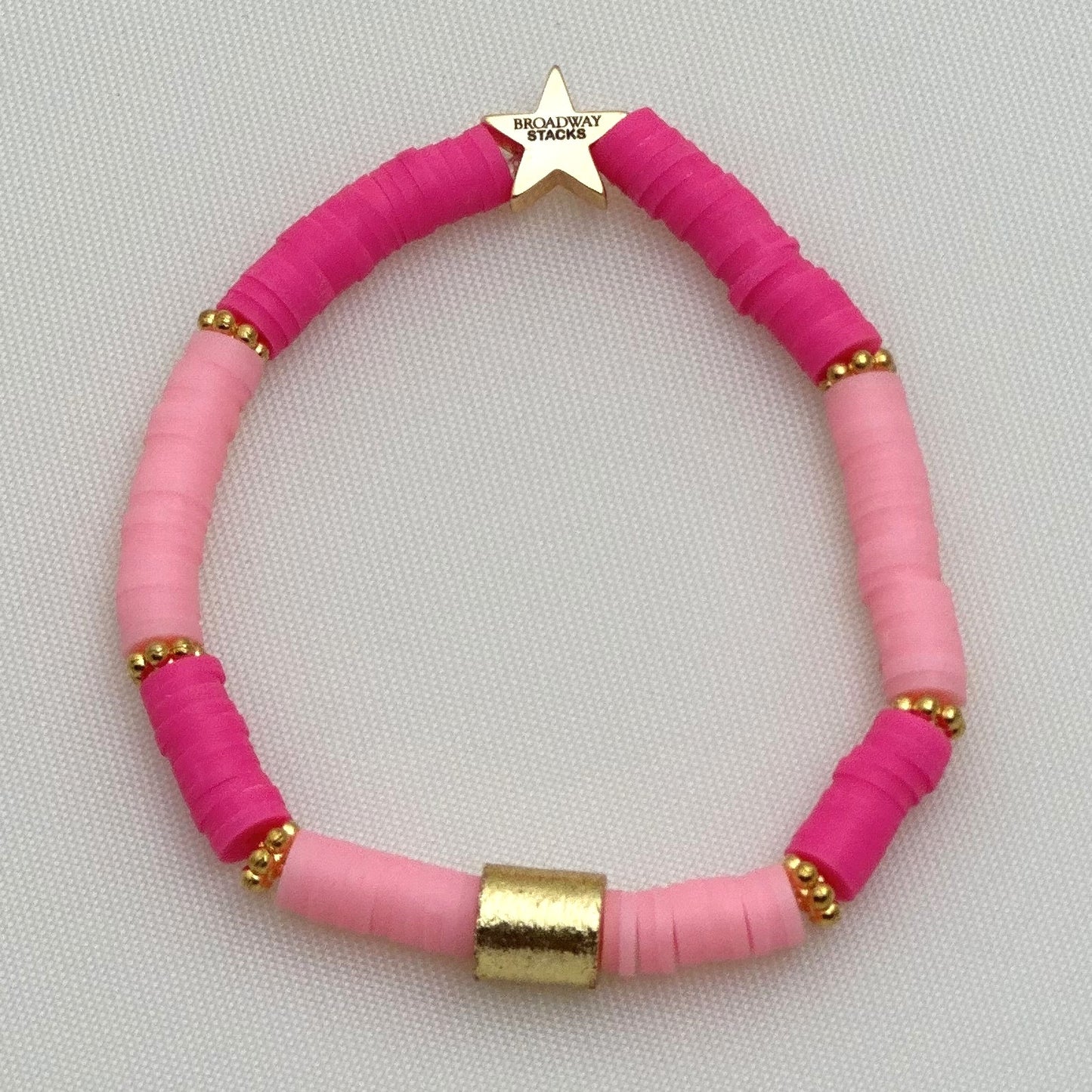 Broadway Stacks KEEP IT POSITIVE collection. 3 stretch bracelets included in Stack. Pinks, white, and gold colored beads. Letter beads that spell show quotes. Broadway Stacks gold star logo bead on back.