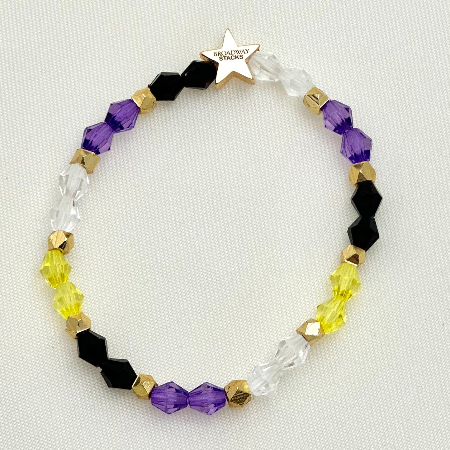 Broadway Stacks PRIDE collection. Avaliable in 8 designs. Red, orange, yellow, green, blue, purple, pink, white, grey, black and gold colored beads. Broadway Stacks gold star logo bead on back.