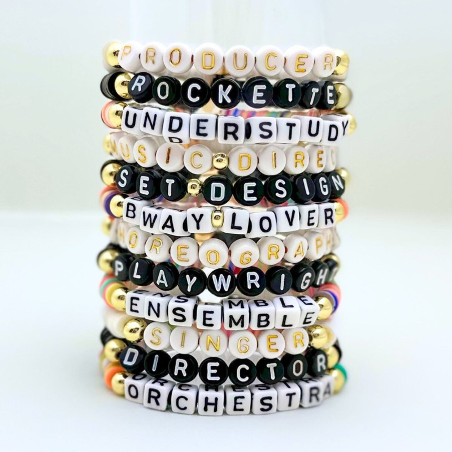 Broadway Stacks SPOTLIGHT Collection. Handcrafted beaded elastic-stretch bracelet with letter beads. Available in many varieties of theatre positions like actor, singer, dancer, director, stage manager, understudy, bway lover, crew, musician, etc. Gold color accents. Available in black, white and mulit-color. Broadway Stacks gold star logo bead on back.