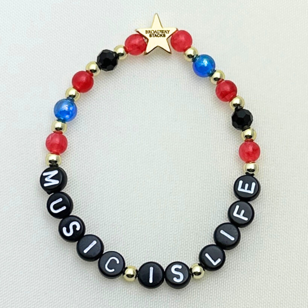 Broadway Stacks JAZZY Collection. 5 stretch bracelets included in Stack. Red, blue, black and gold colored beads. Letter beads that spell quotes. Gold star logo bead to remind you that you shine.