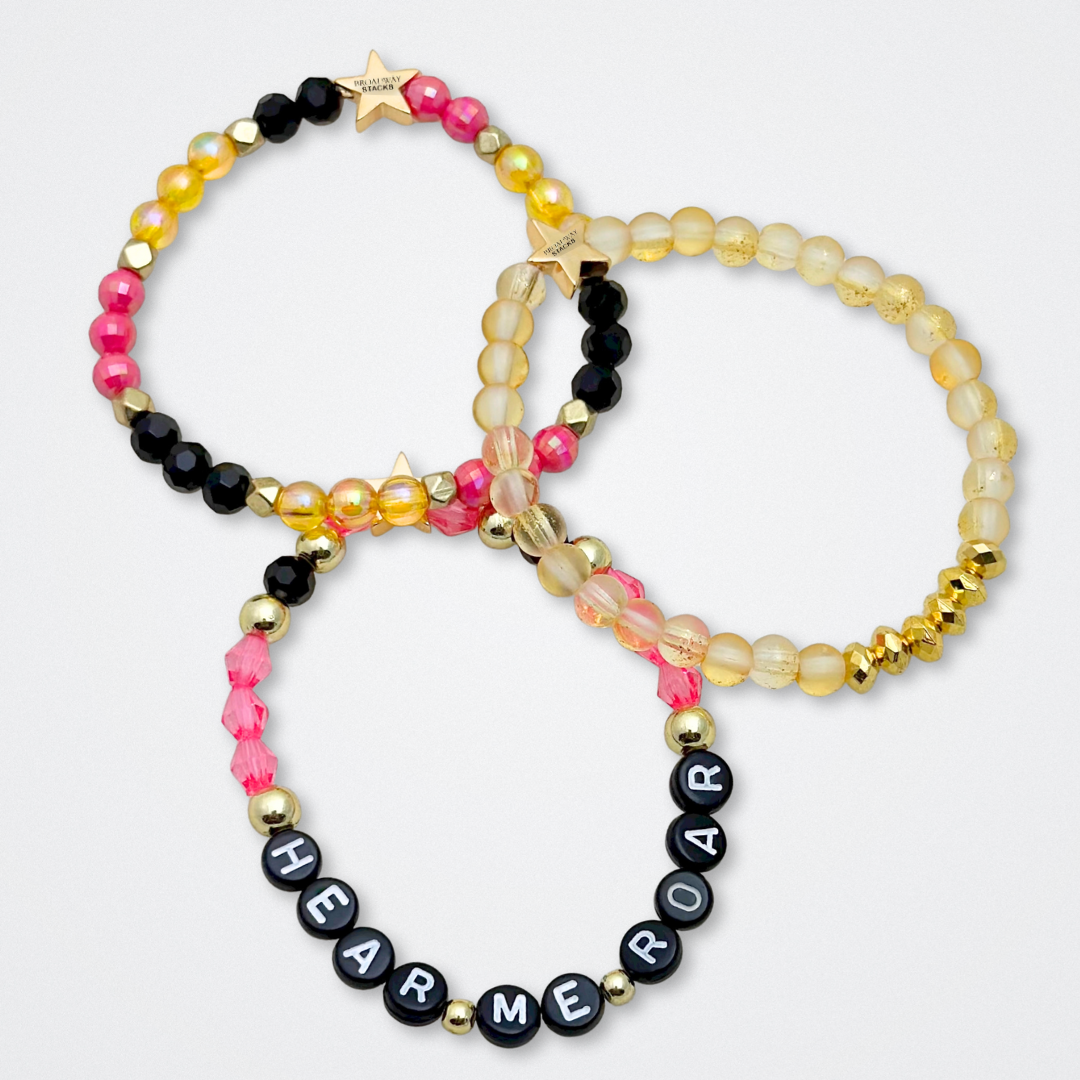 Broadway Stacks De Bois Band collection. 3 stretch bracelets included in Stack. Pinks, golds and black colored beads. Letter beads that spell quotes. Broadway Stacks gold star logo bead to remind you that you shine. & Juliet fans.