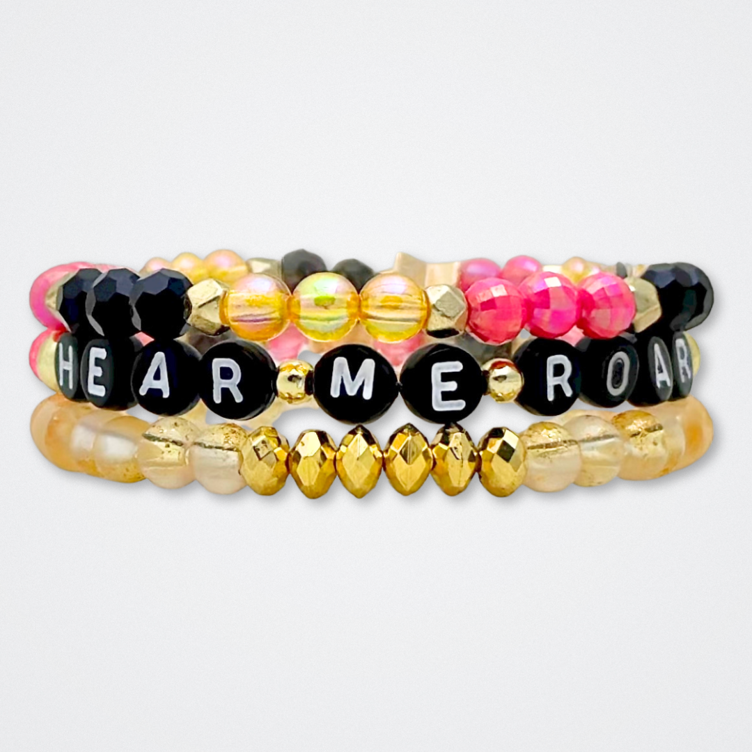 Broadway Stacks De Bois Band collection. 3 stretch bracelets included in Stack. Pinks, golds and black colored beads. Letter beads that spell quotes. Broadway Stacks gold star logo bead to remind you that you shine. & Juliet fans.