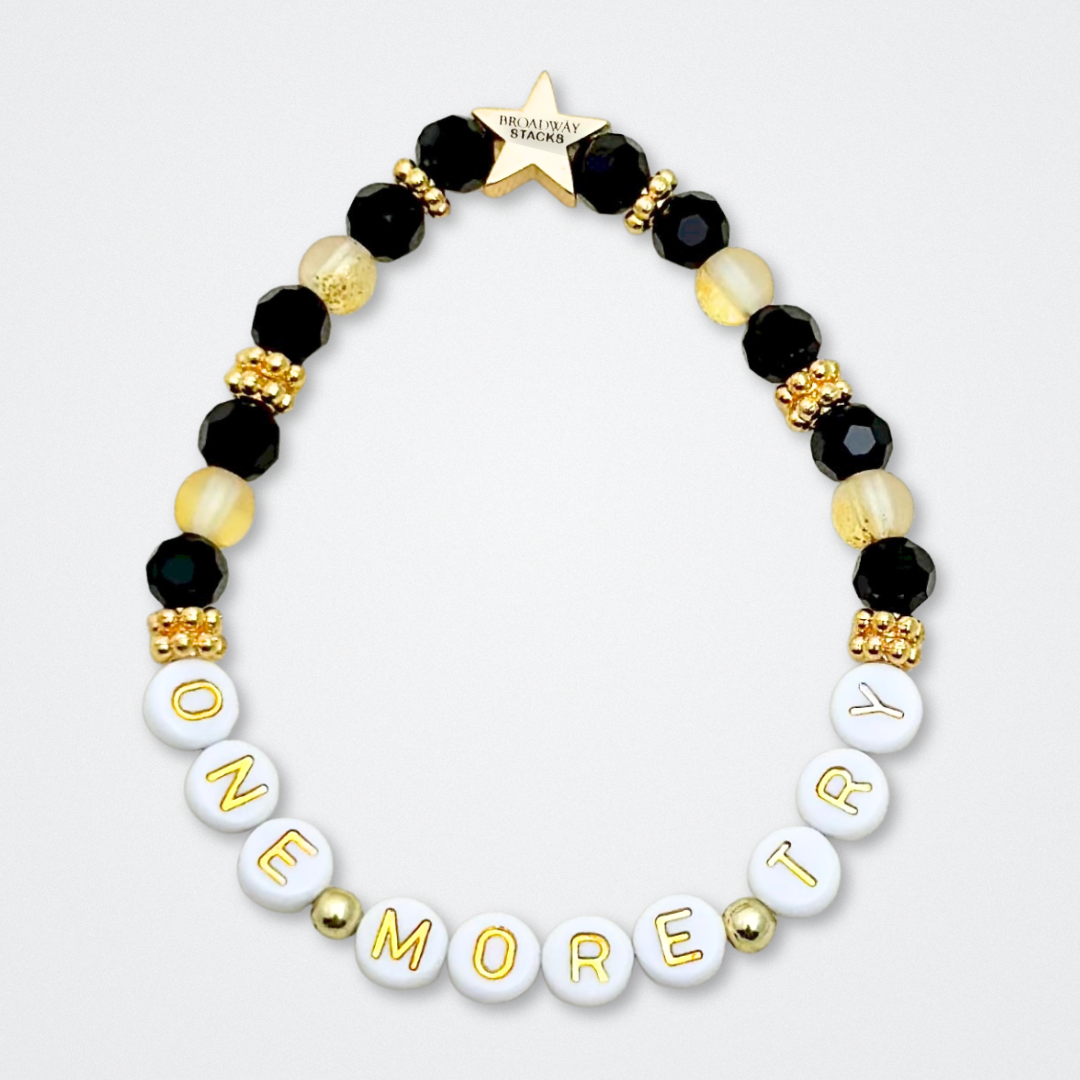 Broadway Stacks De Bois Band collection. 3 stretch bracelets included in Stack. Pinks, golds and black colored beads. Letter beads that spell quotes. Broadway Stacks gold star logo bead to remind you that you shine. & Juliet fans.
