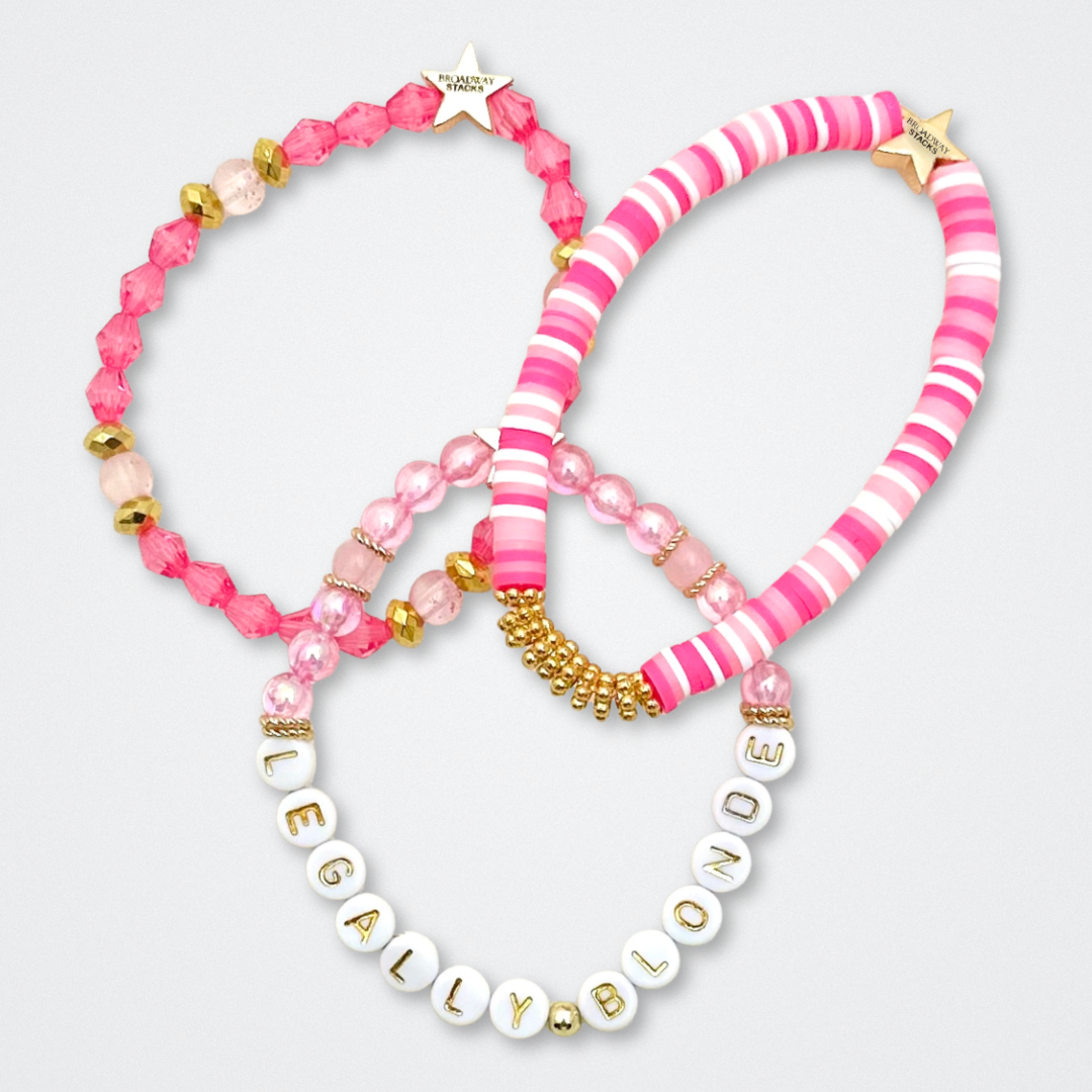 Broadway Stacks KEEP IT POSITIVE Collection. 9 stretch bracelets included in Stack. Pinks, white and gold colored beads. Letter beads that spell quotes. Gold star logo bead to remind you that you shine. Legally Blonde fans.