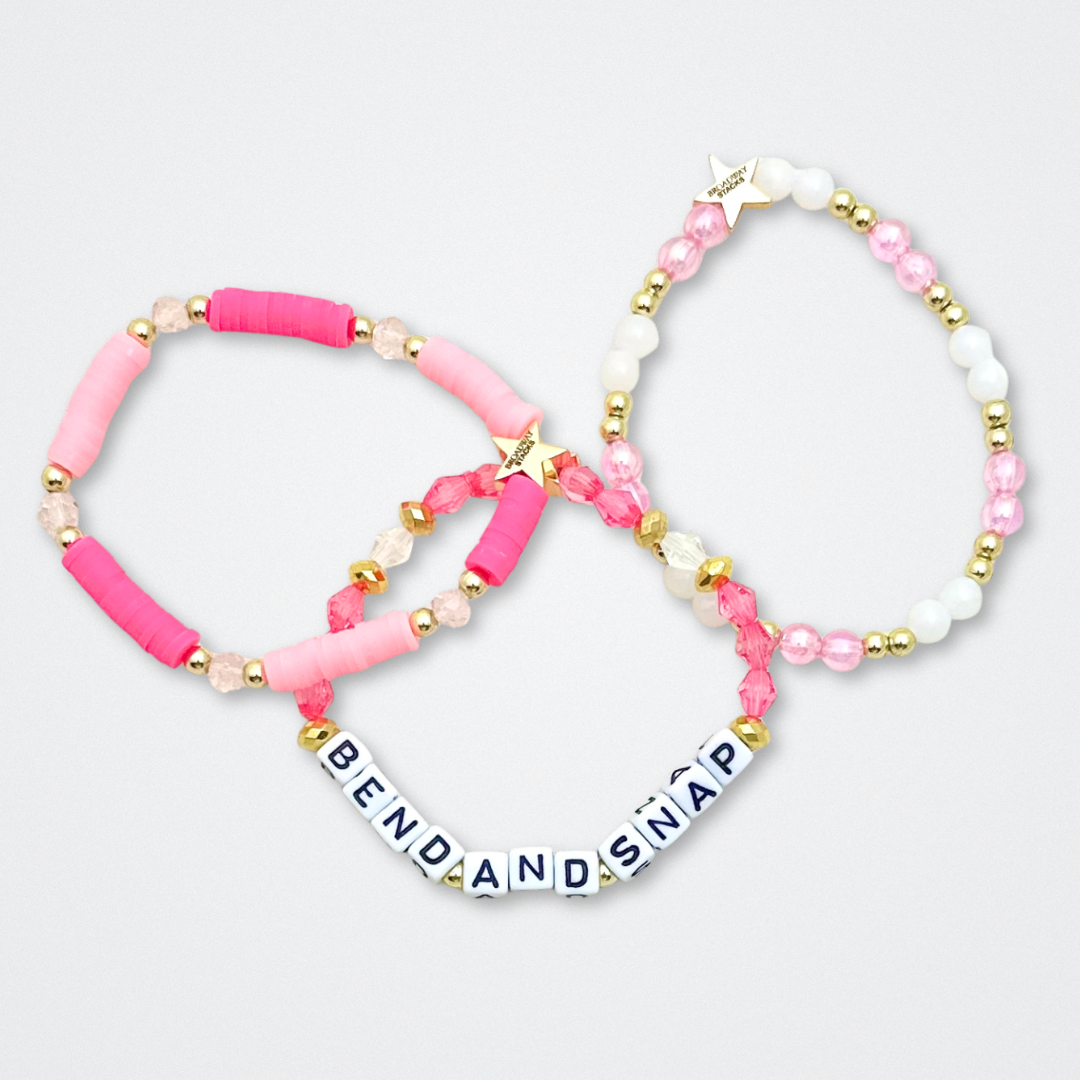 Broadway Stacks KEEP IT POSITIVE Collection. 9 stretch bracelets included in Stack. Pinks, white and gold colored beads. Letter beads that spell quotes. Gold star logo bead to remind you that you shine. Legally Blonde fans.
