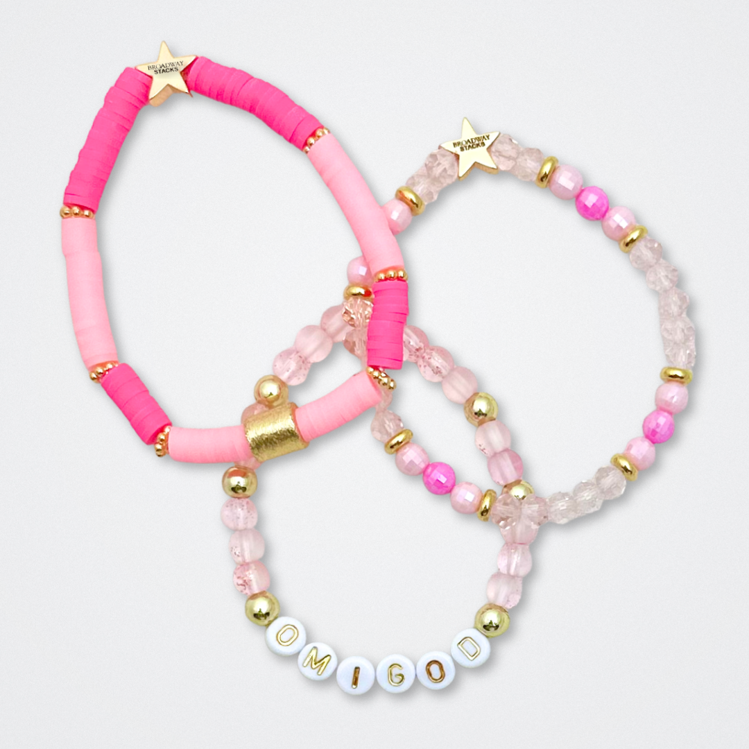 Broadway Stacks KEEP IT POSITIVE Collection. 9 stretch bracelets included in Stack. Pinks, white and gold colored beads. Letter beads that spell quotes. Gold star logo bead to remind you that you shine. Legally Blonde fans.