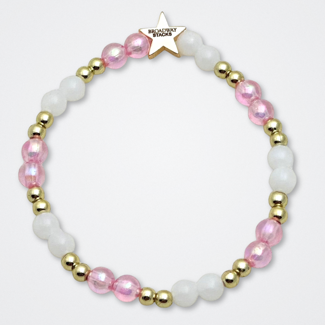 Broadway Stacks KEEP IT POSITIVE Collection. 9 stretch bracelets included in Stack. Pinks, white and gold colored beads. Letter beads that spell quotes. Gold star logo bead to remind you that you shine. Legally Blonde fans.