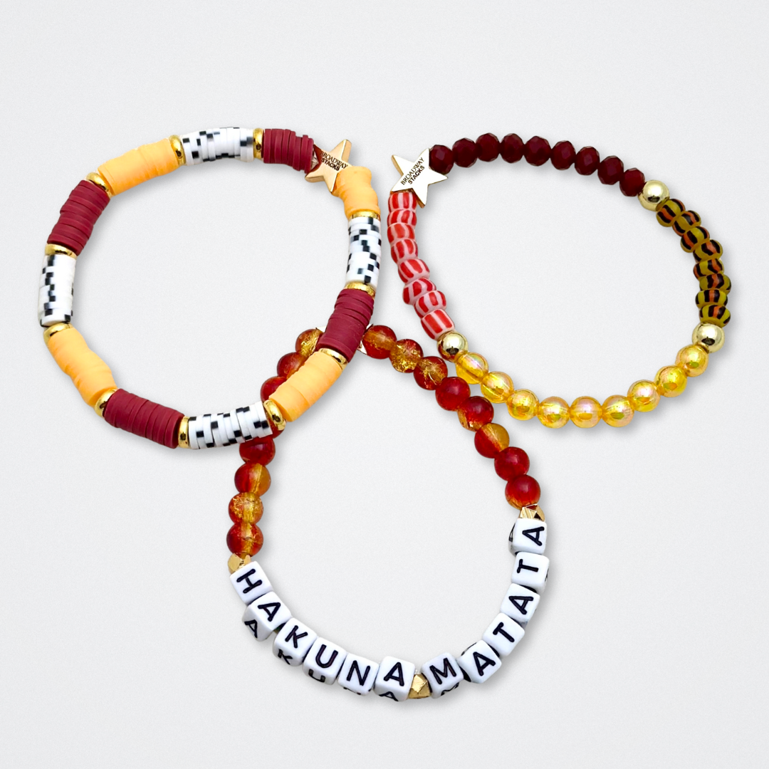Broadway Stacks SAFARI collection. 3 stretch bracelets included in Stack. Dark reds, yellow, orange, white, black and gold colored beads. Animal print beads as well. Letter beads that spell quotes, Gold star logo bead to remind you that you shine.