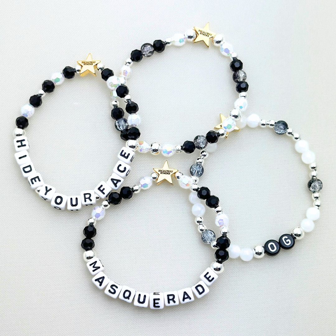 Broadway Stacks MASQUERADE Collection. 4 stretch bracelets included in Stack. Black, white and silver colored beads. Letter beads that spell quotes. Gold star logo bead to remind you that you shine. Phantom of the Opera and Masquerade NYC fans.