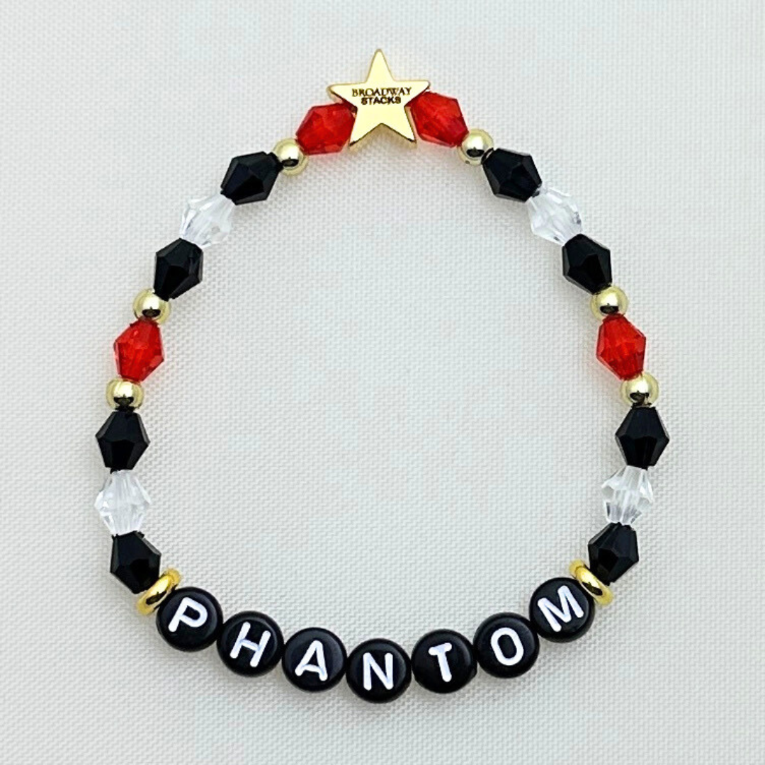 Broadway Stacks MASK collection. 3 stretch bracelets included in Stack. Red, white, gold and black colored beads. Letter beads that spell show quotes. Broadway Stacks gold star logo bead on back.