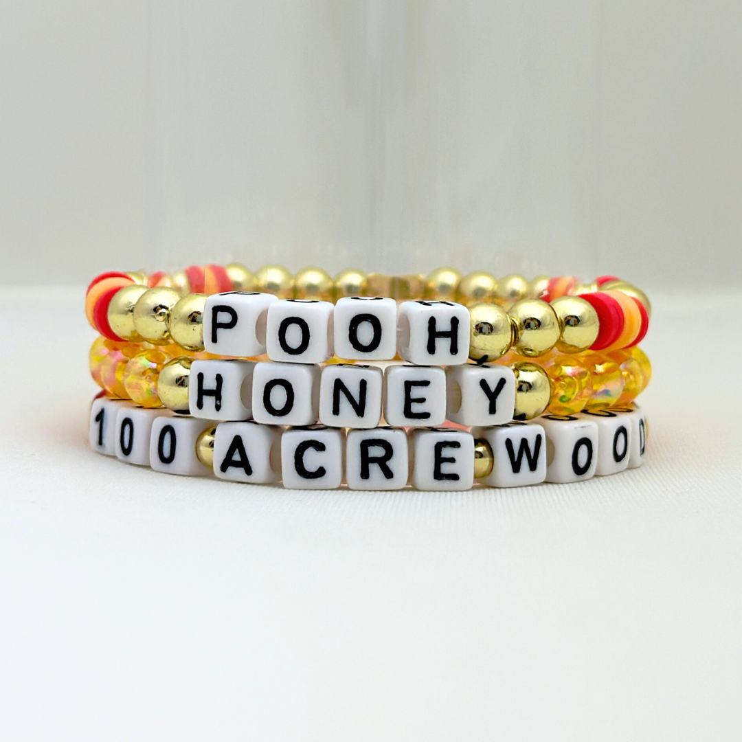 Broadway Stacks HONEY Collection. 3 stretch bracelets included in Stack. Red, yellow and gold colored beads. Letter beads that spell quotes. Gold star logo bead to remind you that you shine.