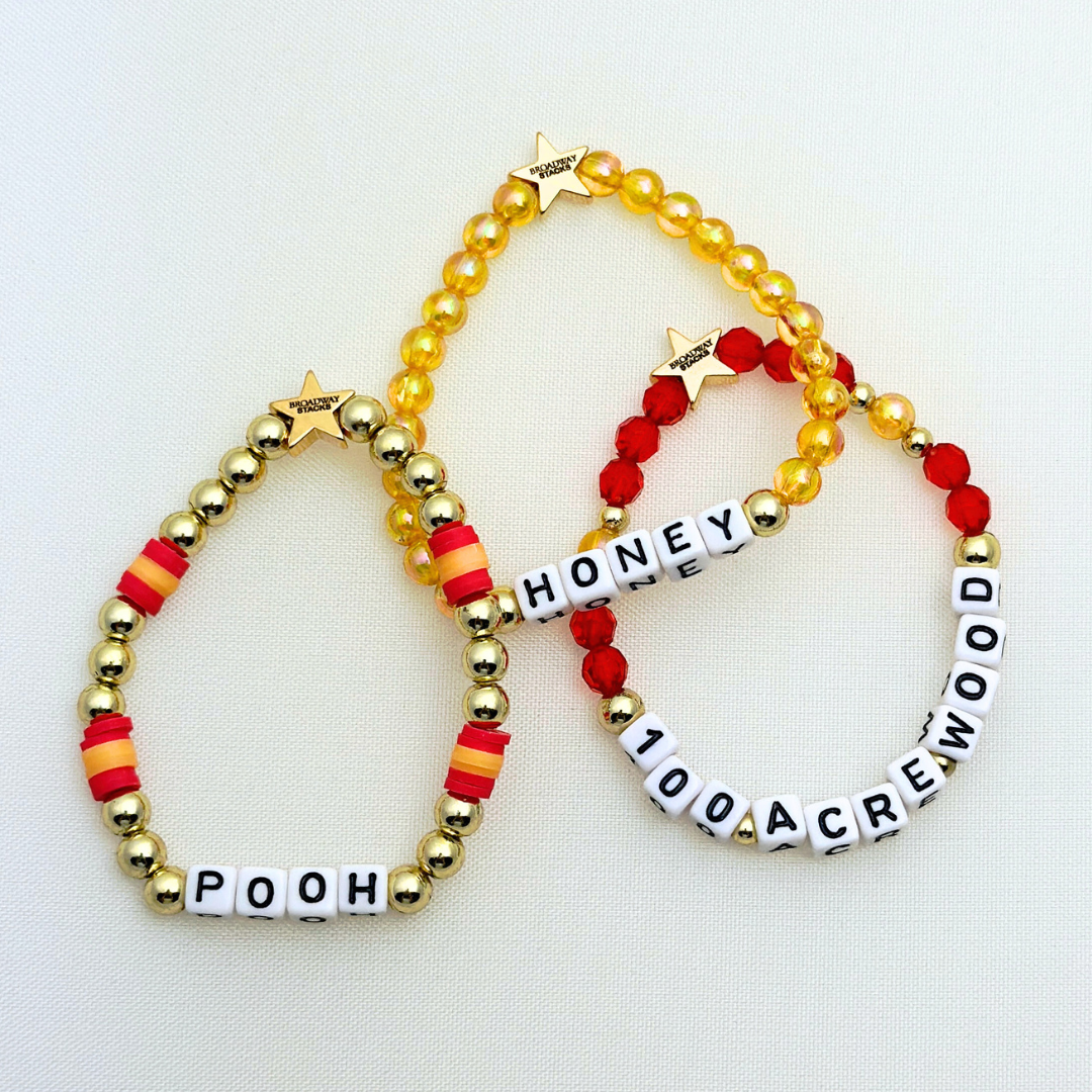 Broadway Stacks HONEY Collection. 3 stretch bracelets included in Stack. Red, yellow and gold colored beads. Letter beads that spell quotes. Gold star logo bead to remind you that you shine.