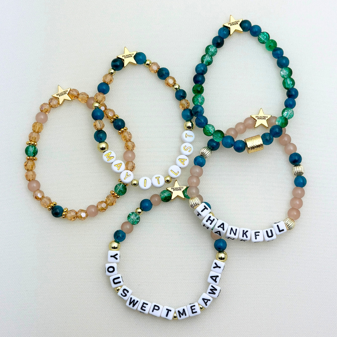 Broadway Stacks SAILOR Collection. 5 stretch bracelets included in Stack. Teal, green, blue and gold colored beads. Letter beads that spell quotes. Gold star logo bead to remind you that you shine.