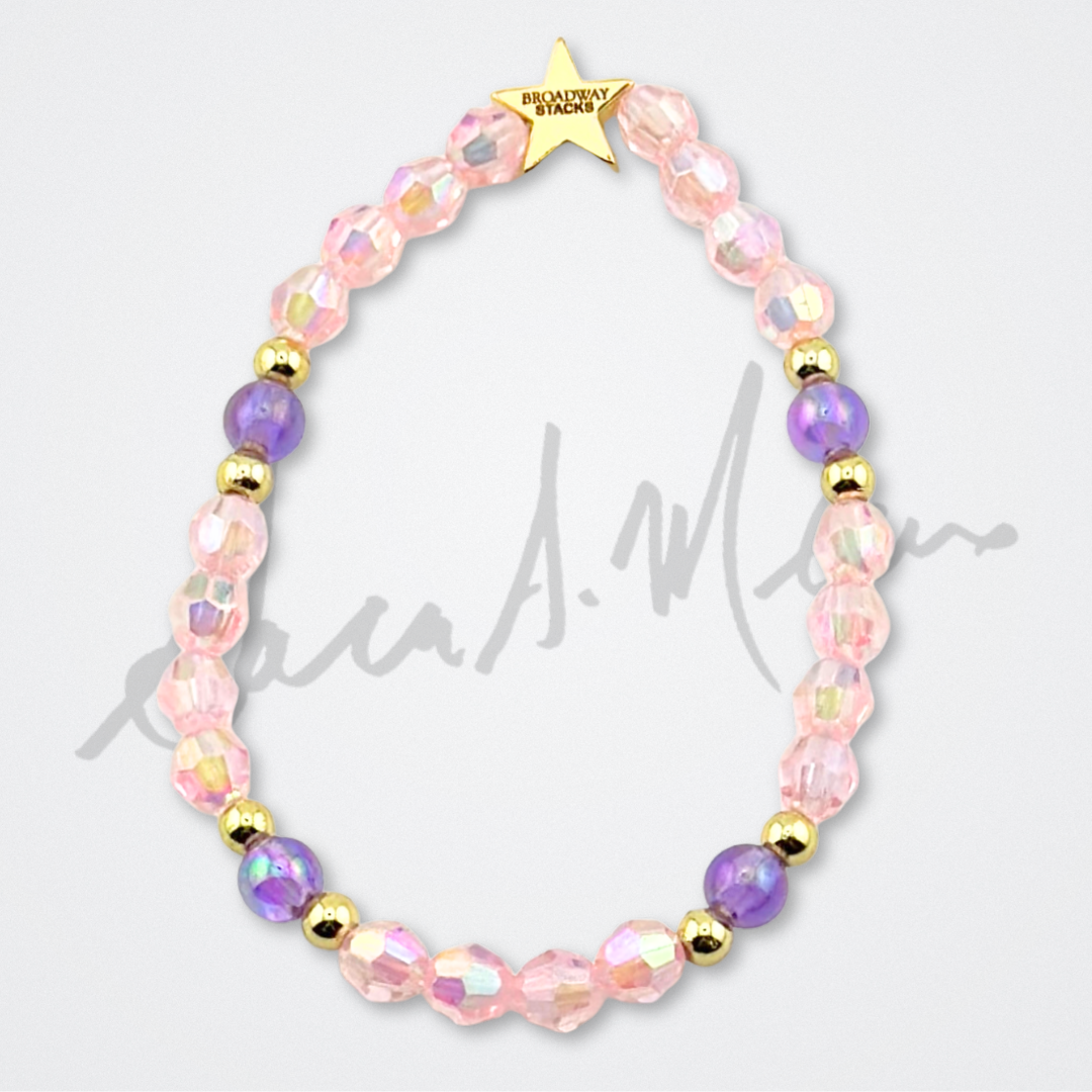 Broadway Stacks Special Edition Sara Mearns STAGE Bracelet Collection. 5 stretch bracelets included in Stack. Purple, pink, clear, white, glitter and gold colored beads. Letter beads that spell quotes. Gold star logo bead to remind you that you shine. Sara Mearns and Ballet fans.