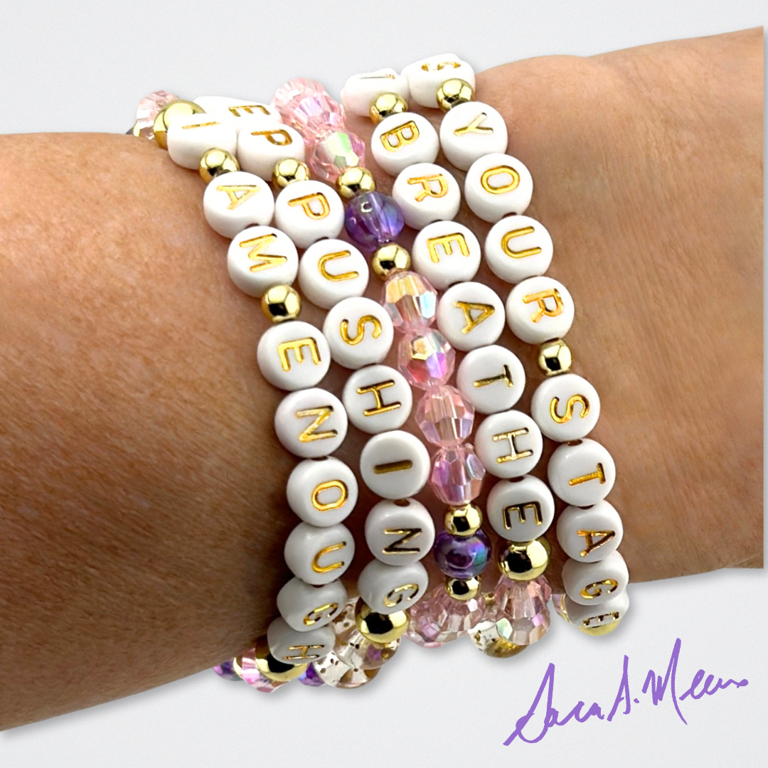 Broadway Stacks Special Edition Sara Mearns STAGE Bracelet Collection. 5 stretch bracelets included in Stack. Purple, pink, clear, white, glitter and gold colored beads. Letter beads that spell quotes. Gold star logo bead to remind you that you shine. Sara Mearns NYCB Principal Dancer and Ballet fans.