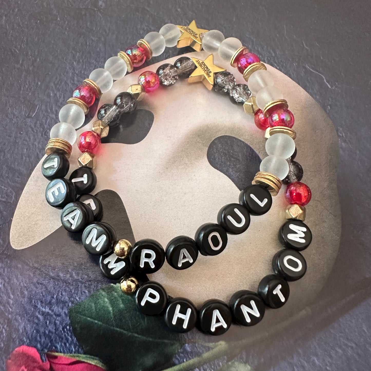 Broadway Stacks MASK collection. Team Phantom, Team Raoul, Team Christine letter bracelets. Stretch bracelet with red, black, gold and beads. Broadway Stacks gold star logo bead.