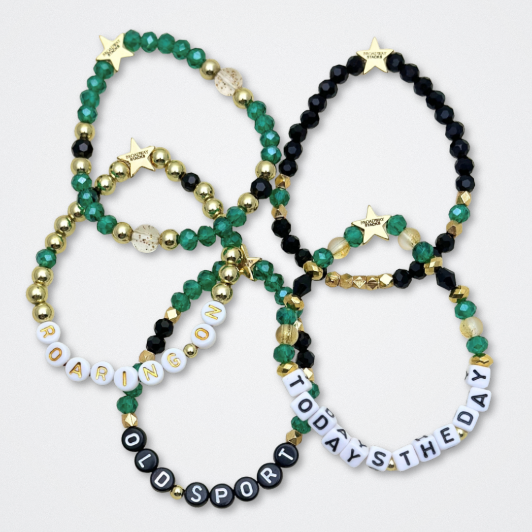 Broadway Stacks NEW MONEY Collection. 5 stretch bracelets included in Stack. Teal, green, black and gold colored beads. Letter beads that spell quotes. Gold star logo bead to remind you that You Shine. Great Gatsby fans.