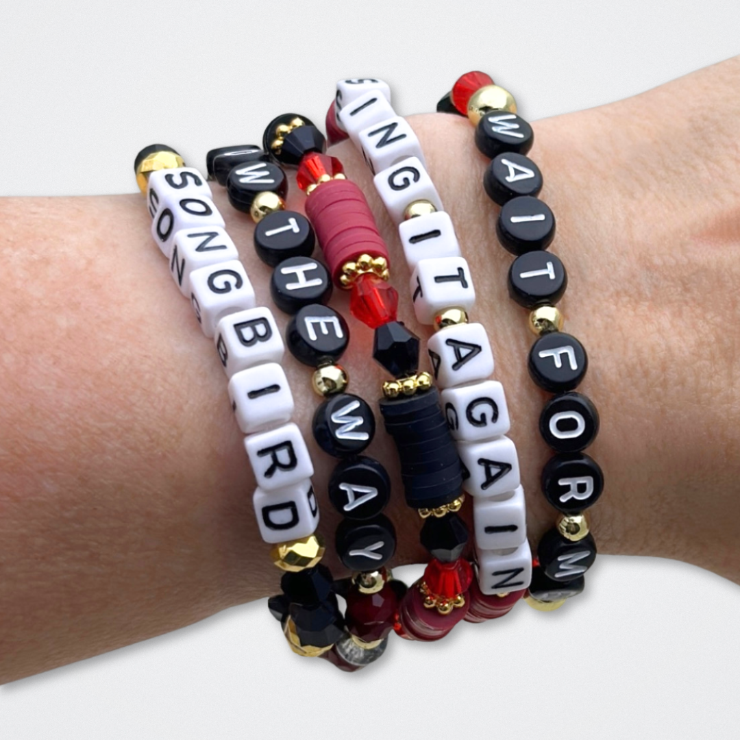 Broadway Stacks UNDERWORLD collection. 5 stretch bracelets included in Stack. Red, garnet, black and gold colored beads. Letter beads that spell quotes. Gold star logo bead to remind you that you shine. Hadestown fans.