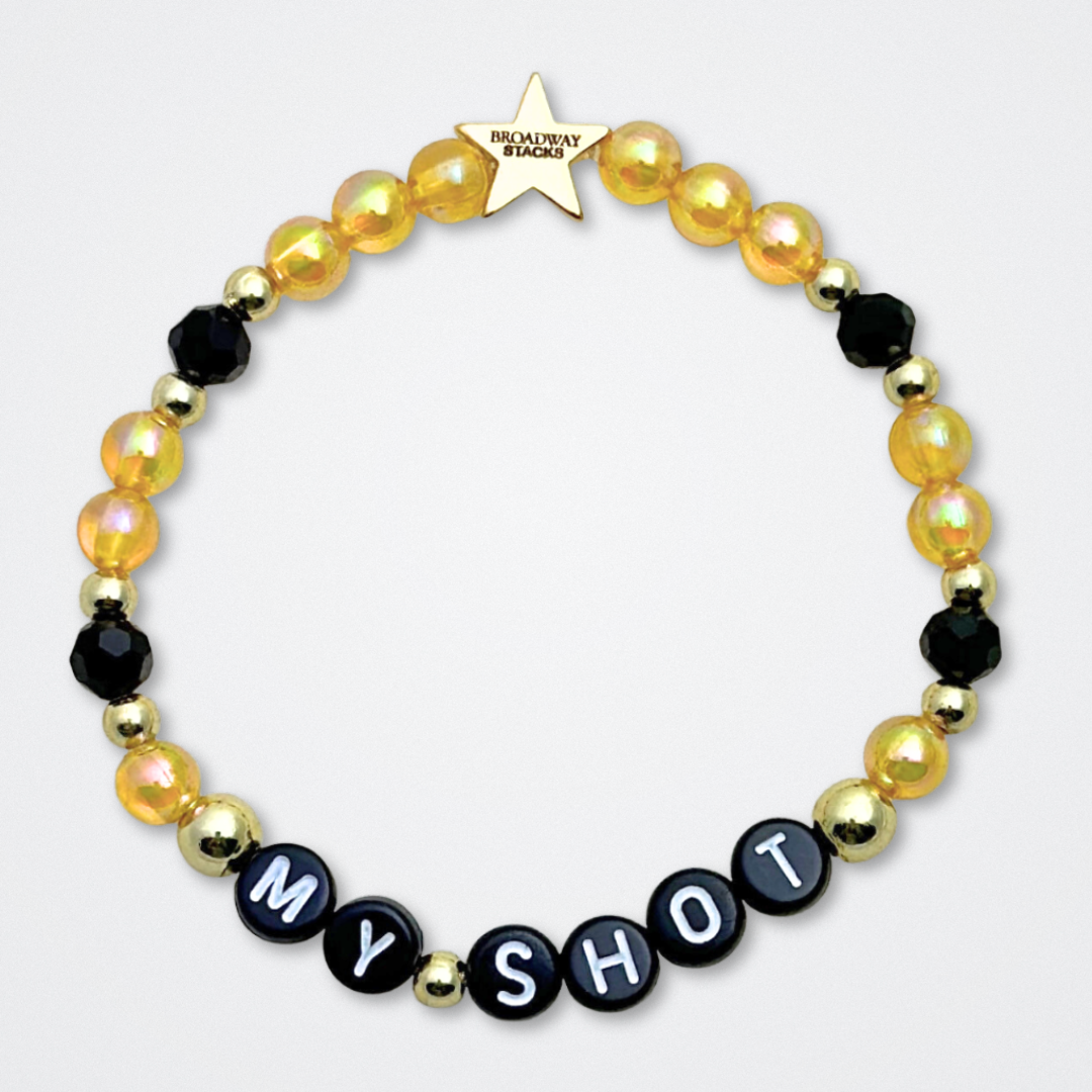 Broadway Stacks REVOLUTION Collection. 5 stretch bracelets included in Stack. Yellow, white, black and gold colored beads. Letter beads that spell quotes. Gold star logo bead to remind you that You Shine. Hamilton the Musical fans.
