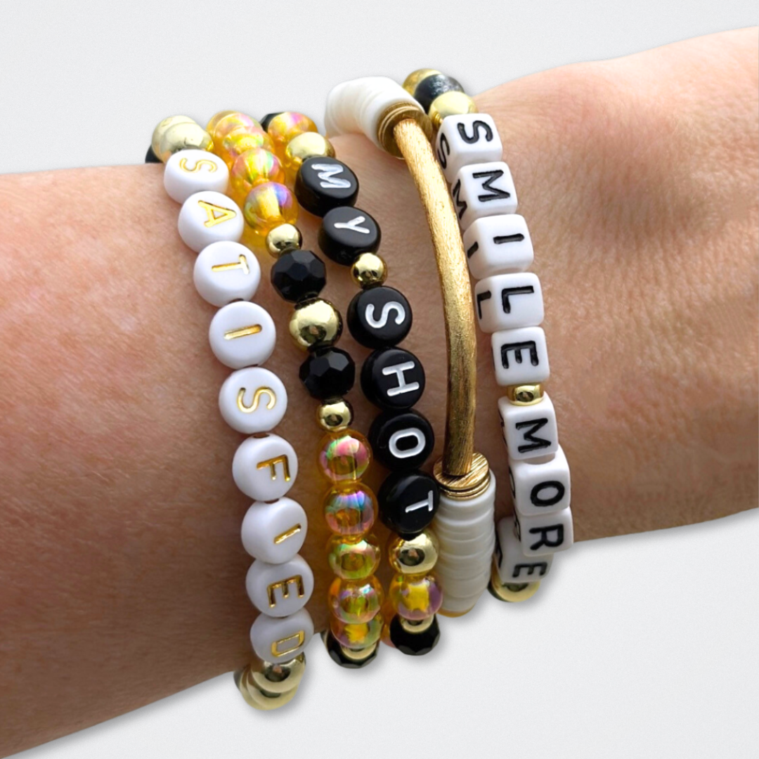 Broadway Stacks REVOLUTION Collection. 5 stretch bracelets included in Stack. Yellow, white, black and gold colored beads. Letter beads that spell quotes. Gold star logo bead to remind you that You Shine. Hamilton the Musical fans.