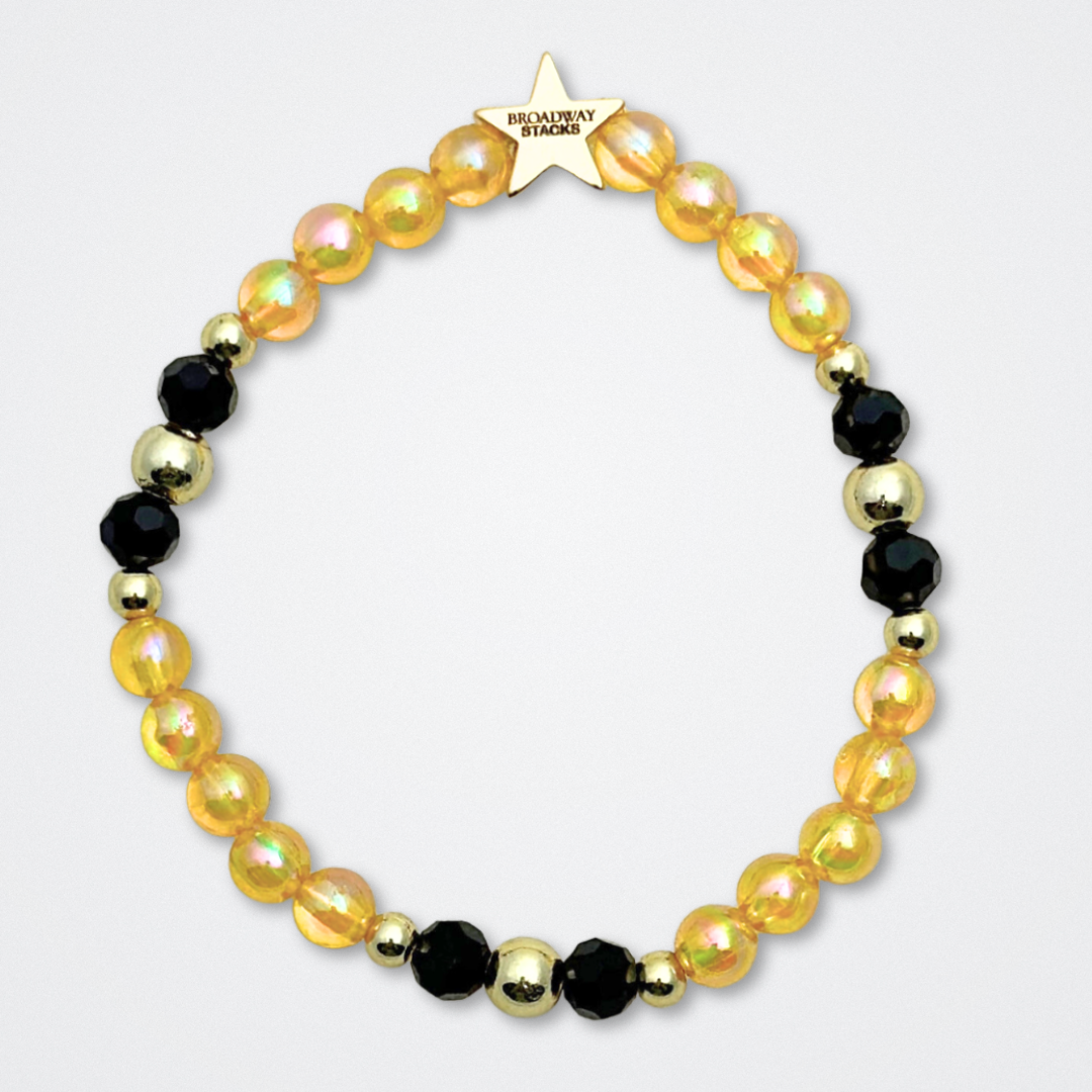 Broadway Stacks REVOLUTION Collection. 5 stretch bracelets included in Stack. Yellow, white, black and gold colored beads. Letter beads that spell quotes. Gold star logo bead to remind you that You Shine. Hamilton the Musical fans.
