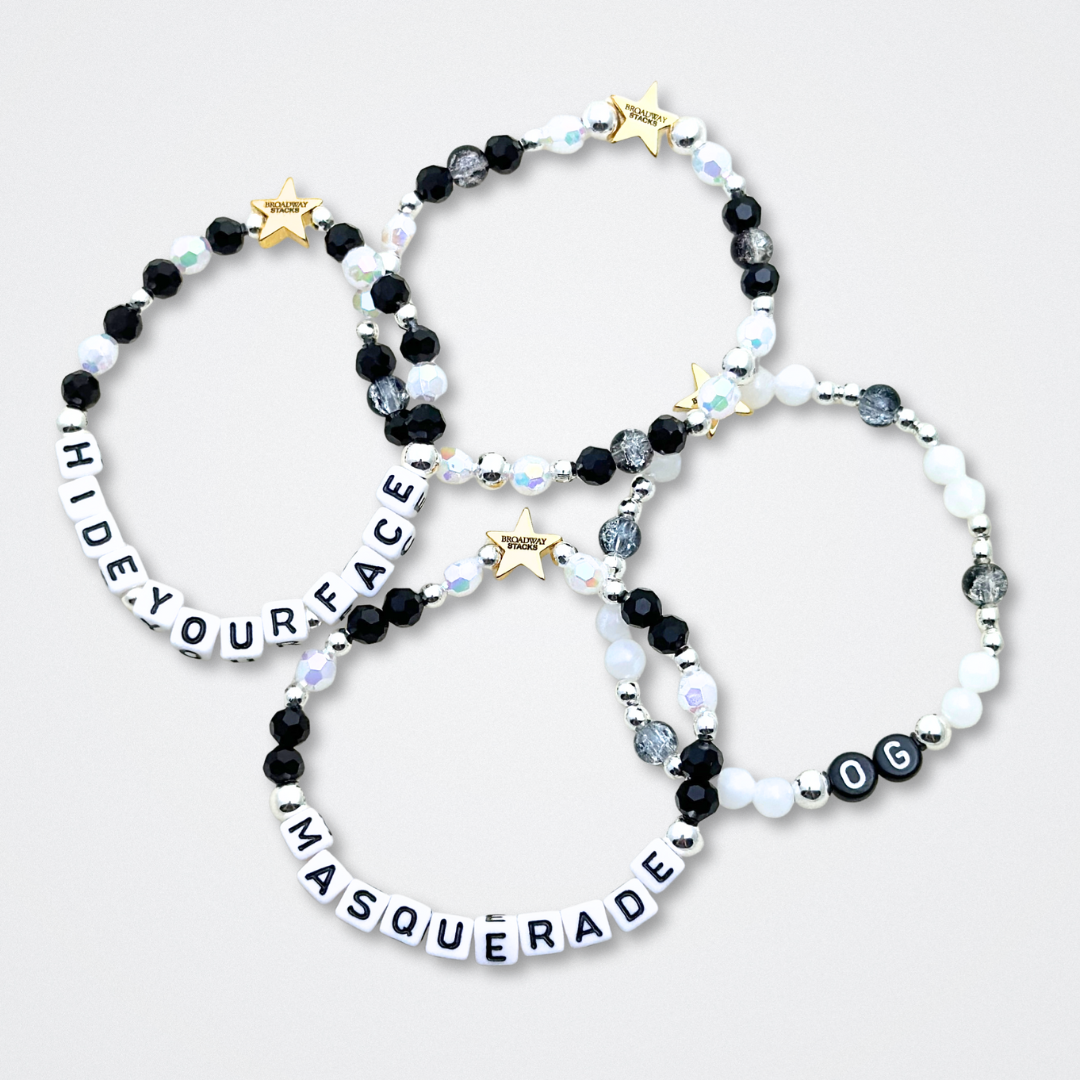 Broadway Stacks MASQUERADE Collection. 4 stretch bracelets included in Stack. Black, white and silver colored beads. Letter beads that spell quotes. Gold star logo bead to remind you that you shine. Phantom of the Opera and Masquerade NYC fans.