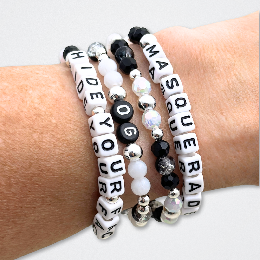 Broadway Stacks MASQUERADE Collection. 4 stretch bracelets included in Stack. Black, white and silver colored beads. Letter beads that spell quotes. Gold star logo bead to remind you that you shine. Phantom of the Opera and Masquerade NYC fans.