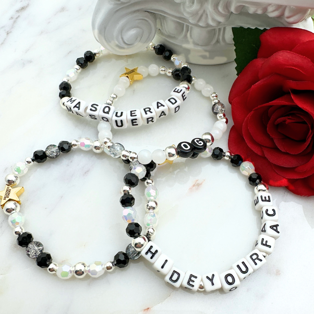 Broadway Stacks MASQUERADE Collection. 4 stretch bracelets included in Stack. Black, white and silver colored beads. Letter beads that spell quotes. Gold star logo bead to remind you that you shine. Phantom of the Opera and Masquerade NYC fans.