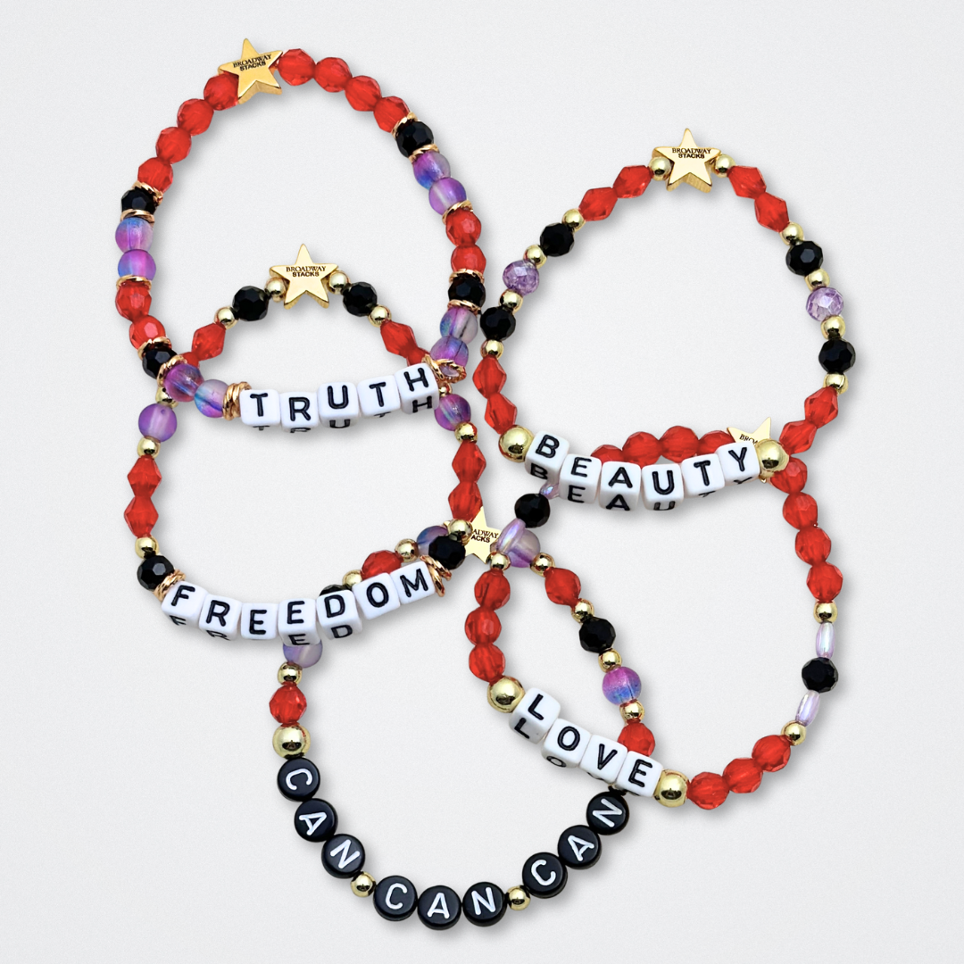 Broadway Stacks RED LIGHT Collection. 5 stretch bracelets included in Stack. Red, purple, black and gold colored beads. Letter beads that spell quotes. Gold star logo bead to remind you that You Shine. Moulin Rouge fans.
