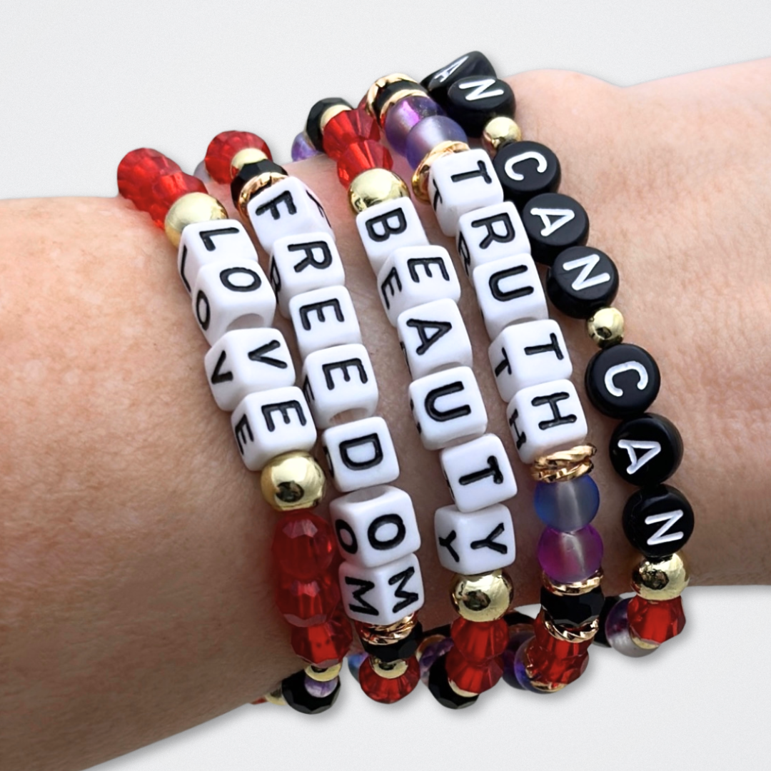 Broadway Stacks RED LIGHT Collection. 5 stretch bracelets included in Stack. Red, purple, black and gold colored beads. Letter beads that spell quotes. Gold star logo bead to remind you that You Shine. Moulin Rouge fans.