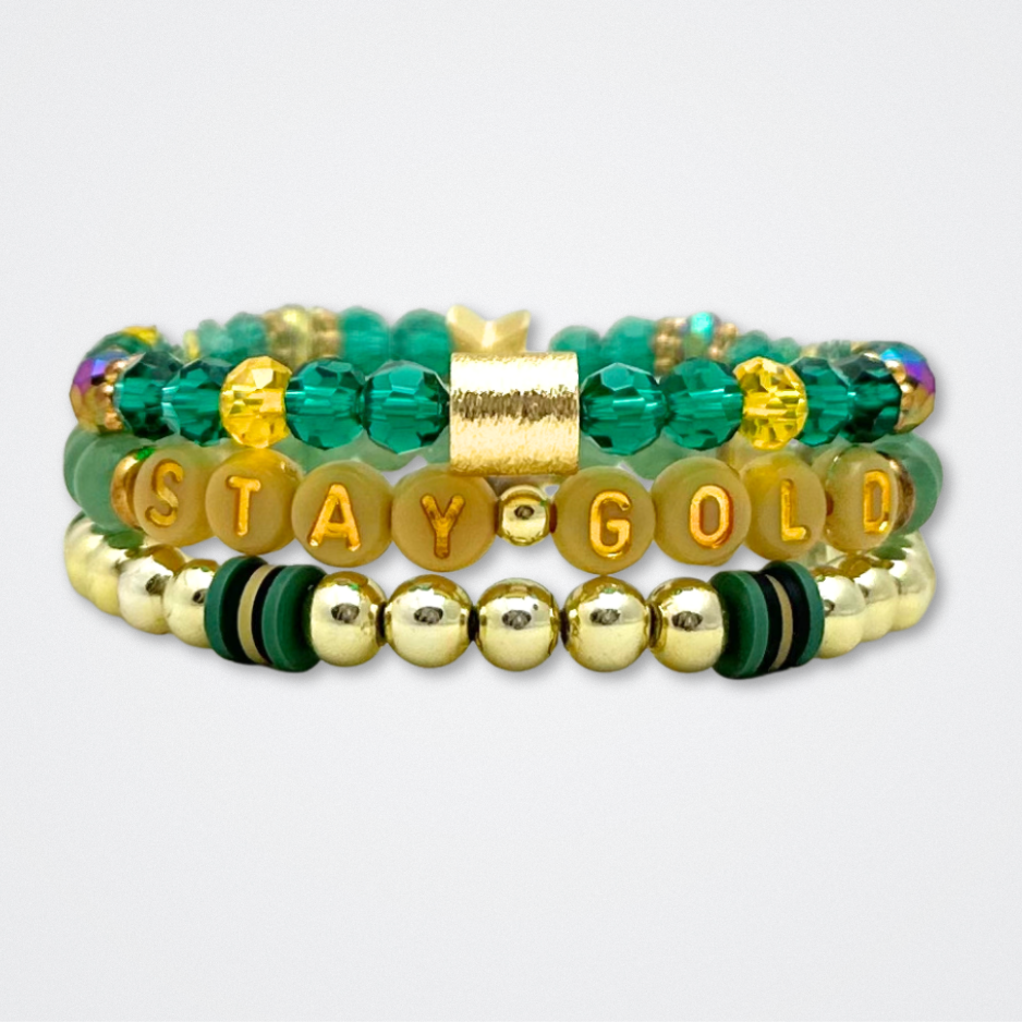 Broadway Stacks STAY GOLD collection. Stretch bracelets included in Stack. Gold, yellow, green and grey colored beads. Letter beads that have show quote or name. Broadway Stacks gold star logo bead to remind you that You Shine. The Outsiders the Musical fans.
