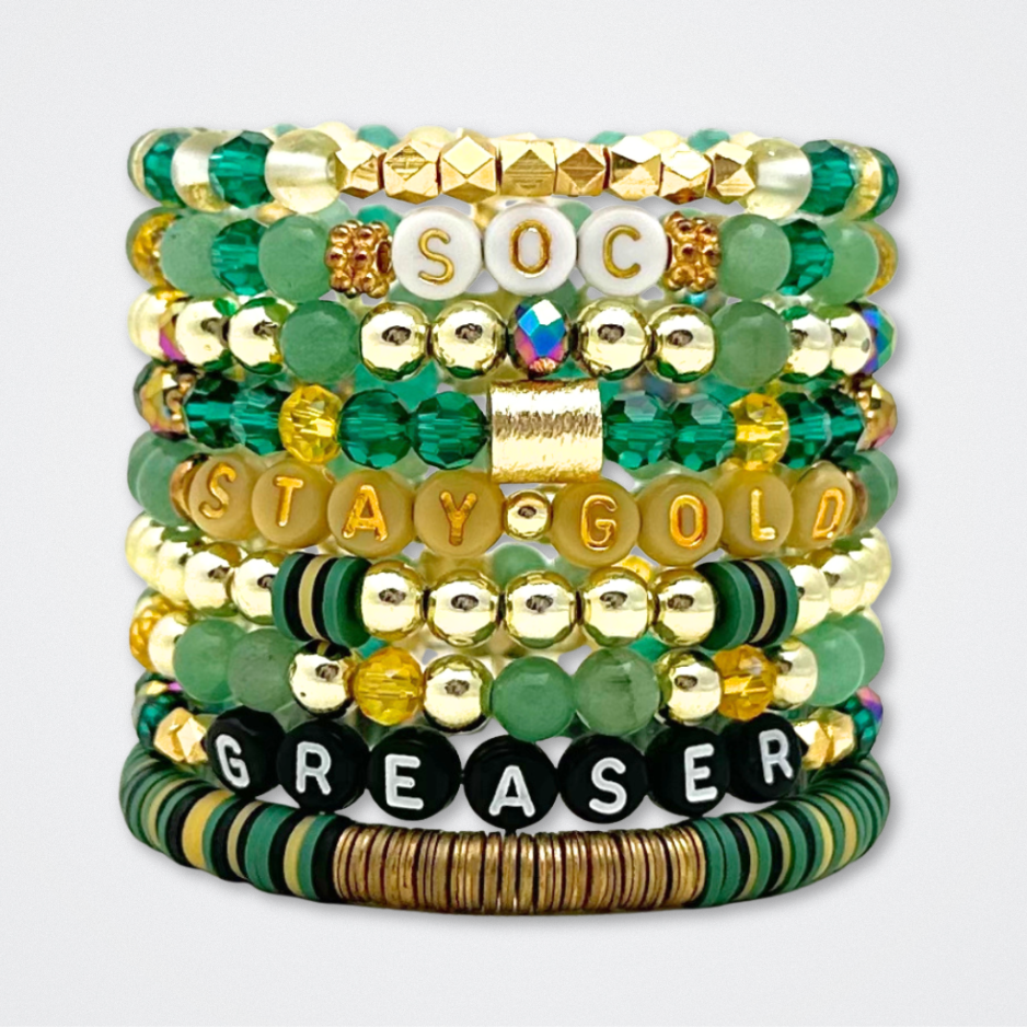 Broadway Stacks STAY GOLD collection. Stretch bracelets included in Stack. Gold, yellow, green and grey colored beads. Letter beads that have show quote or name. Broadway Stacks gold star logo bead to remind you that You Shine. The Outsiders the Musical fans.