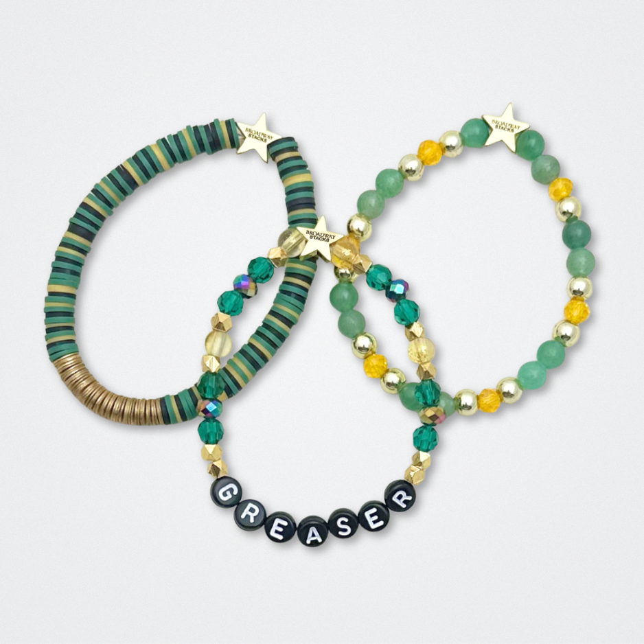 Broadway Stacks STAY GOLD collection. Stretch bracelets included in Stack. Gold, yellow, green and grey colored beads. Letter beads that have show quote or name. Broadway Stacks gold star logo bead to remind you that You Shine. The Outsiders the Musical fans.