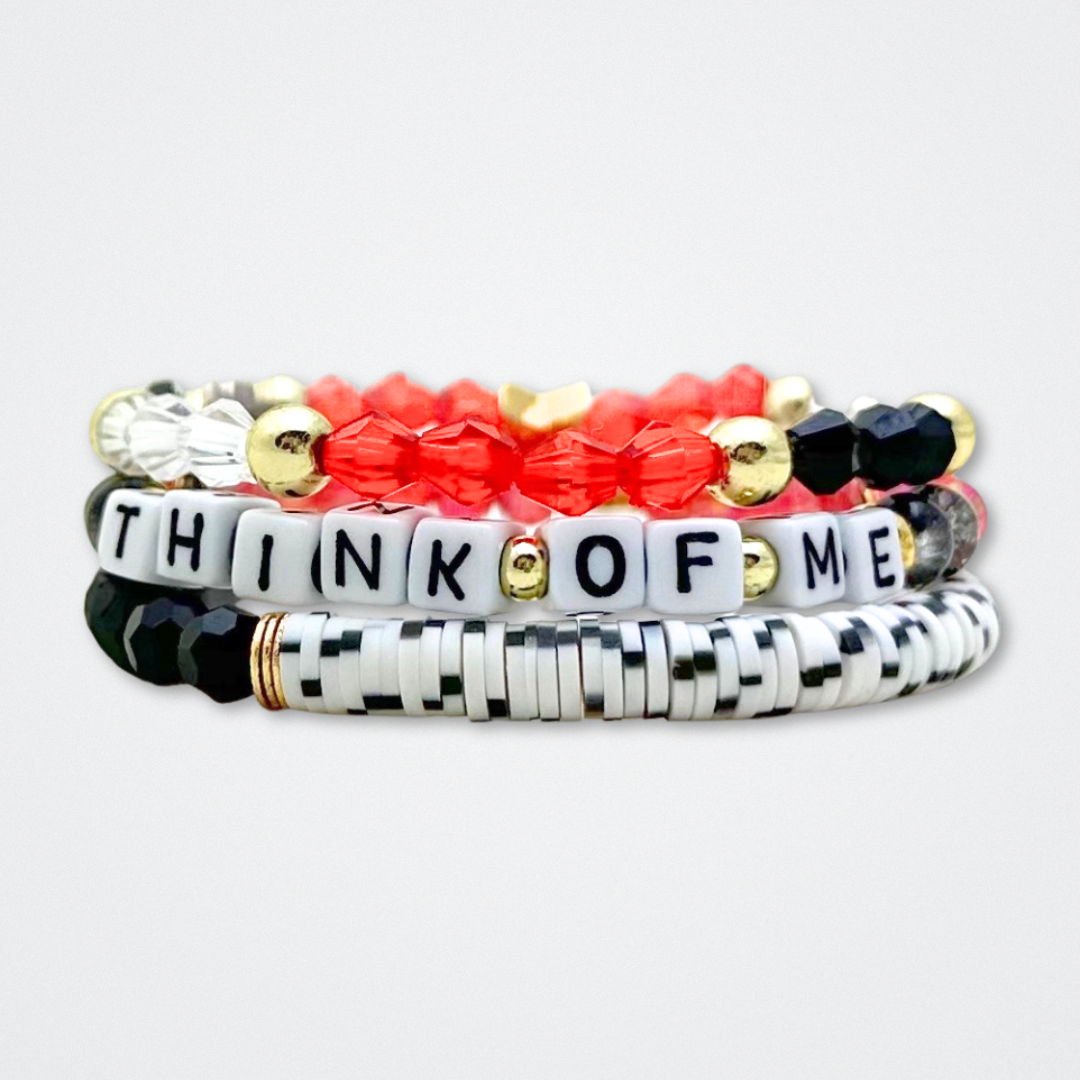 Broadway Stacks MASK collection. Bead bracelets included in Stack. Red, black, white and gold colored beads. Letter beads that spell quotes. Team Phantom, Team Christine, Team Raoul. Gold star logo bead to remind you that You Shine. Phantom of the Opera and Masquerade fans.
