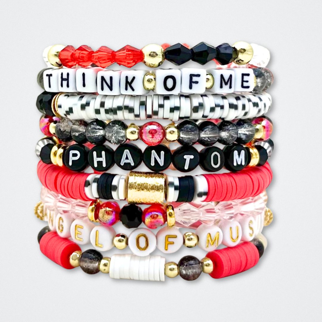 Broadway Stacks MASK collection. Bead bracelets included in Stack. Red, black, white and gold colored beads. Letter beads that spell quotes. Team Phantom, Team Christine, Team Raoul. Gold star logo bead to remind you that You Shine. Phantom of the Opera and Masquerade fans.