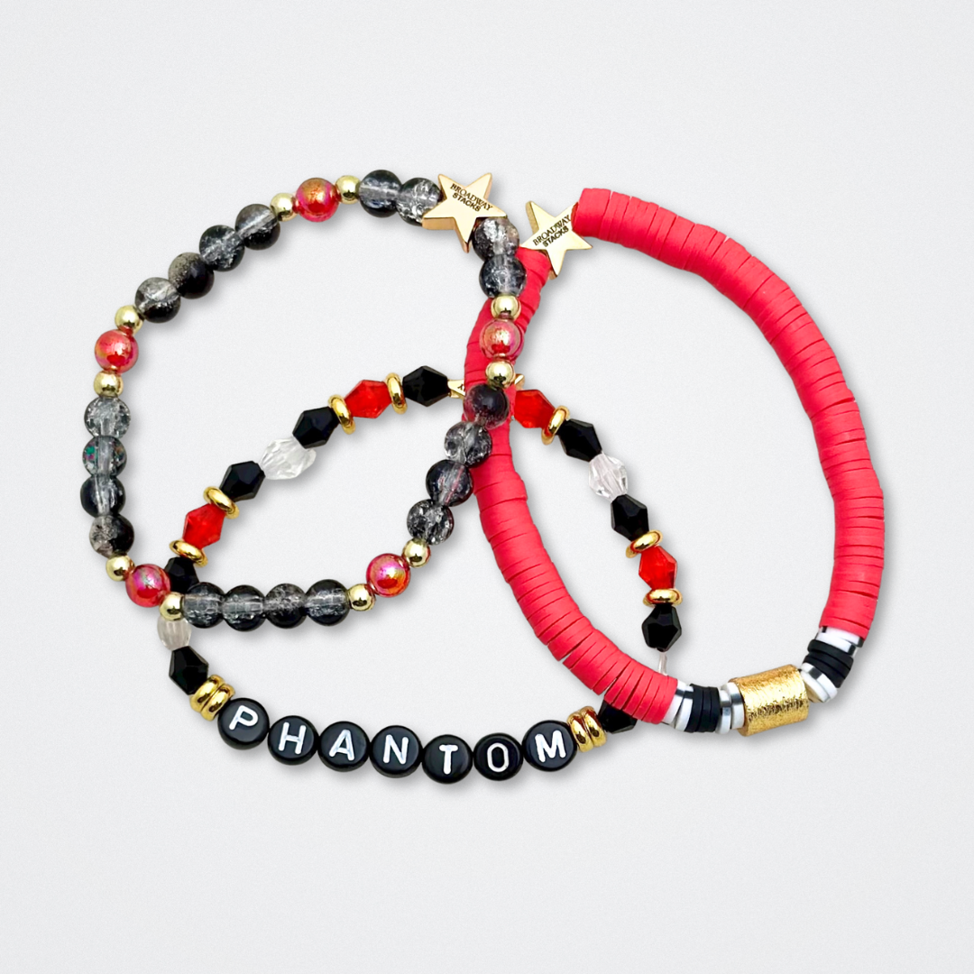 Broadway Stacks MASK collection. Bead bracelets included in Stack. Red, black, white and gold colored beads. Letter beads that spell quotes. Team Phantom, Team Christine, Team Raoul. Gold star logo bead to remind you that You Shine. Phantom of the Opera and Masquerade fans.