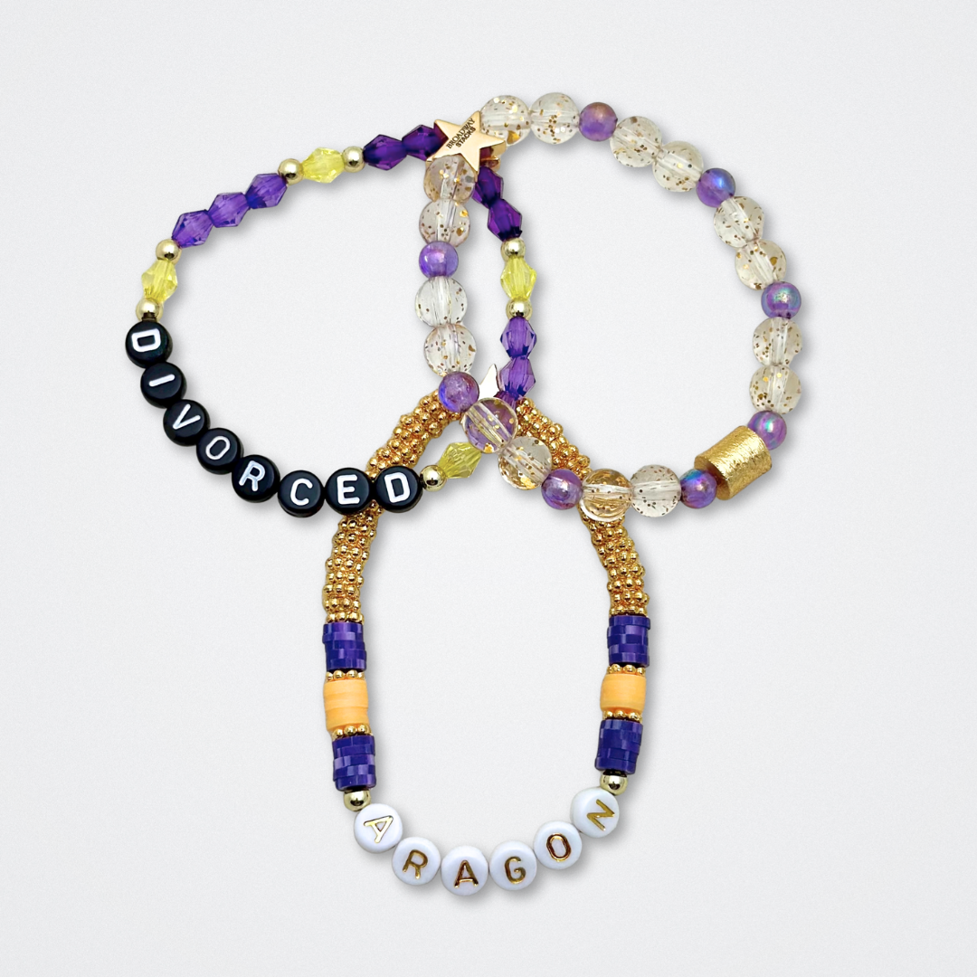 Broadway Stacks QUEEN collection. Stretch bracelets included in Stack. Gold, yellow, green, white, red, pink and blue colored beads. Letter beads that spell each queen. Also Herstory collection. Broadway Stacks gold star logo bead to remind you that You Shine. SIX the Musical fans.