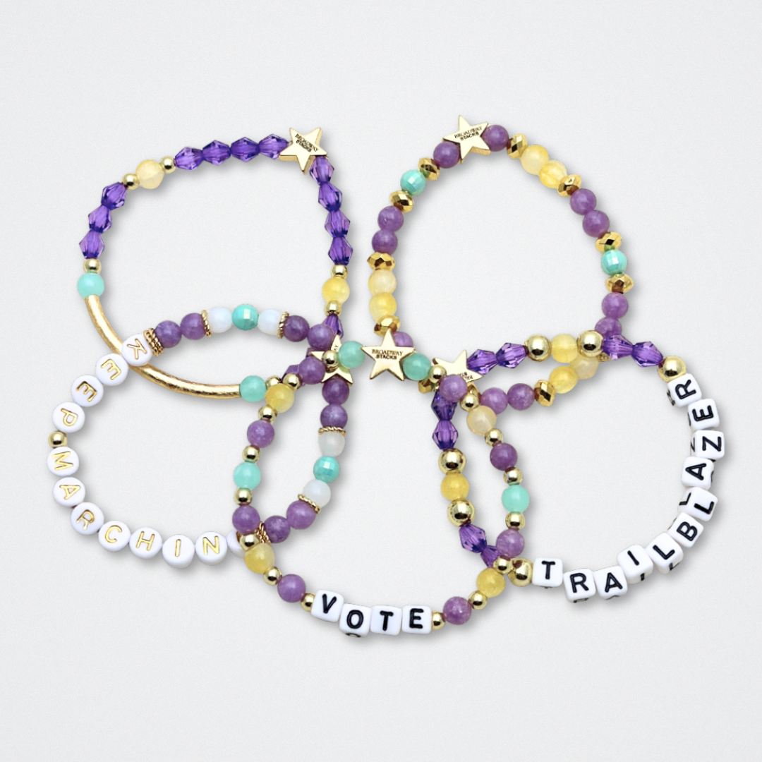 Broadway Stacks CAMPAIGN Collection. 5 stretch bracelets included in Stack. Purple, yellow, teal and gold colored beads. Letter beads that spell quotes. Gold star logo bead to remind you that you shine. Suffs fans.