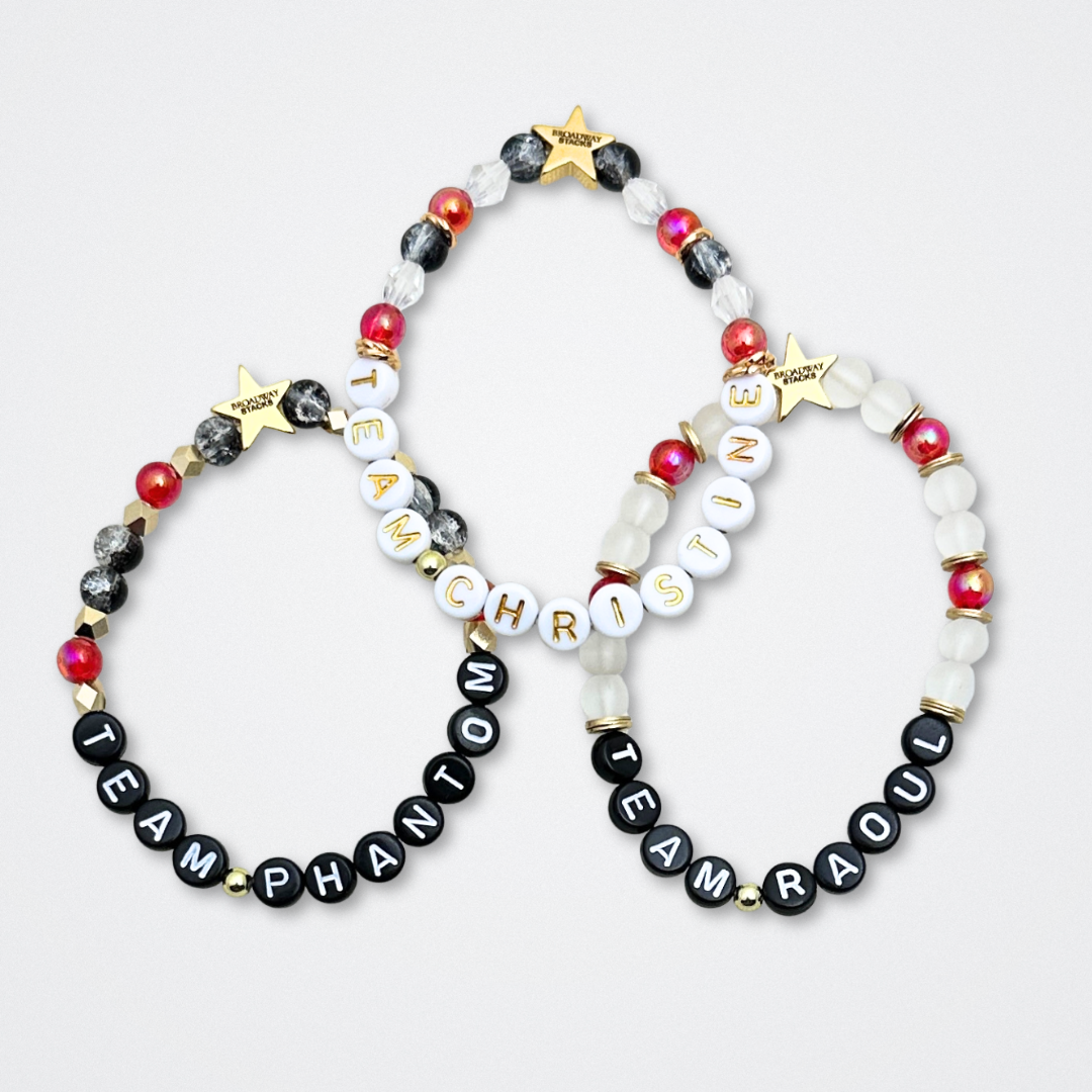 Broadway Stacks MASK collection. Bead bracelets included in Stack. Red, black, white and gold colored beads. Letter beads that spell quotes. Team Phantom, Team Christine, Team Raoul. Gold star logo bead to remind you that You Shine. Phantom of the Opera and Masquerade fans.