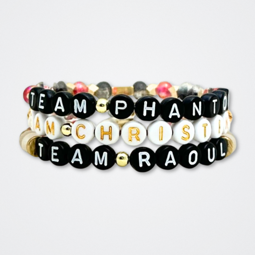 Broadway Stacks MASK collection. Bead bracelets included in Stack. Red, black, white and gold colored beads. Letter beads that spell quotes. Team Phantom, Team Christine, Team Raoul. Gold star logo bead to remind you that You Shine. Phantom of the Opera and Masquerade fans.