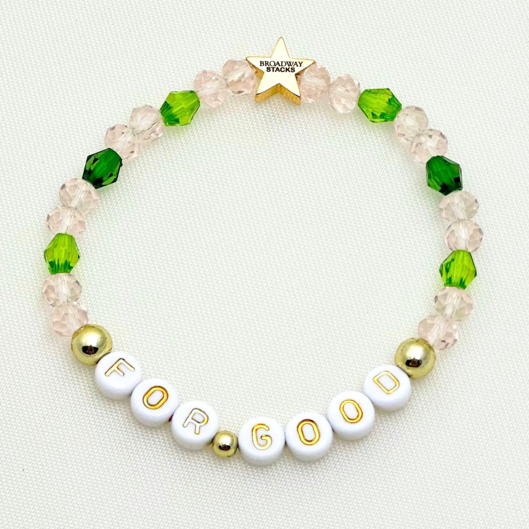 Broadway Stacks Witch collection. 3 stretch bracelets included in Stack. Greens, pinks, black and gold colored beads. Letter beads that spell Wicked. Gold star logo bead on every bracelet.