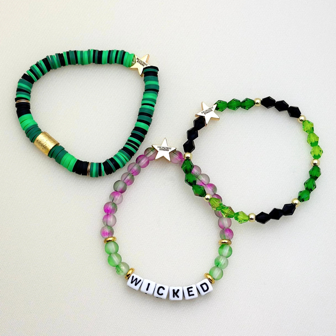 Broadway Stacks Witch collection. 3 stretch bracelets included in Stack. Greens, pinks, black and gold colored beads. Letter beads that spell Wicked. Gold star logo bead on every bracelet.