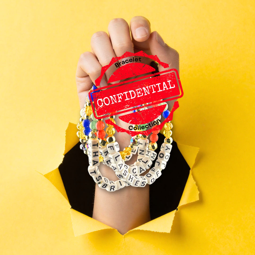 Broadway Stacks CONFIDENTIAL Collection inspired by Operation Mincemeat. Hand holding beaded bracelets with yellow background.